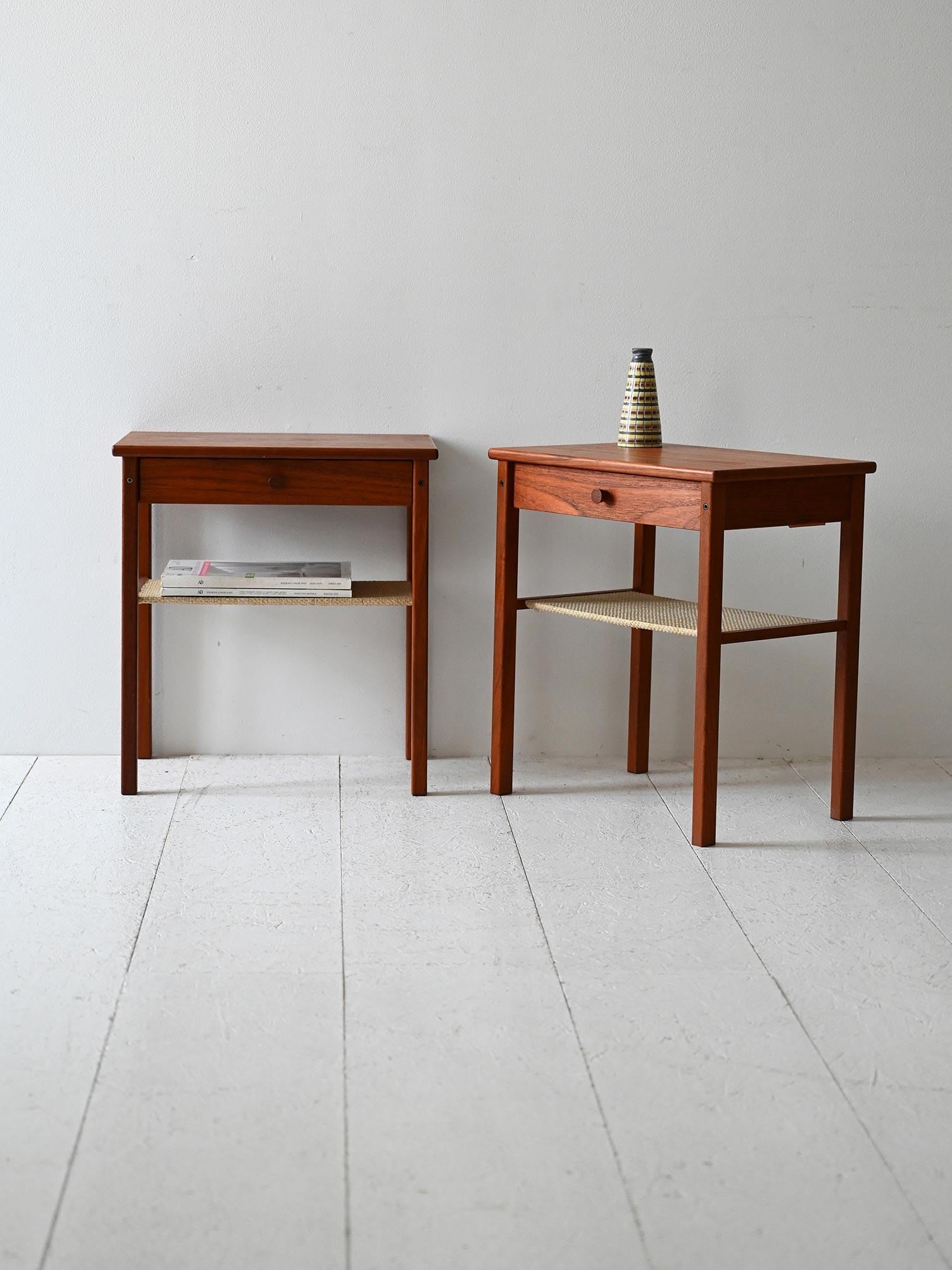 Comodini vintage anni ’50 in teak laccato scuro, con mensola in tessuto di corda beige.

Coppia di comodini originali scandinavi anni ’50 in teak laccato scuro. Ogni pezzo è dotato di cassetto con maniglia a incasso e mensola inferiore rivestita in