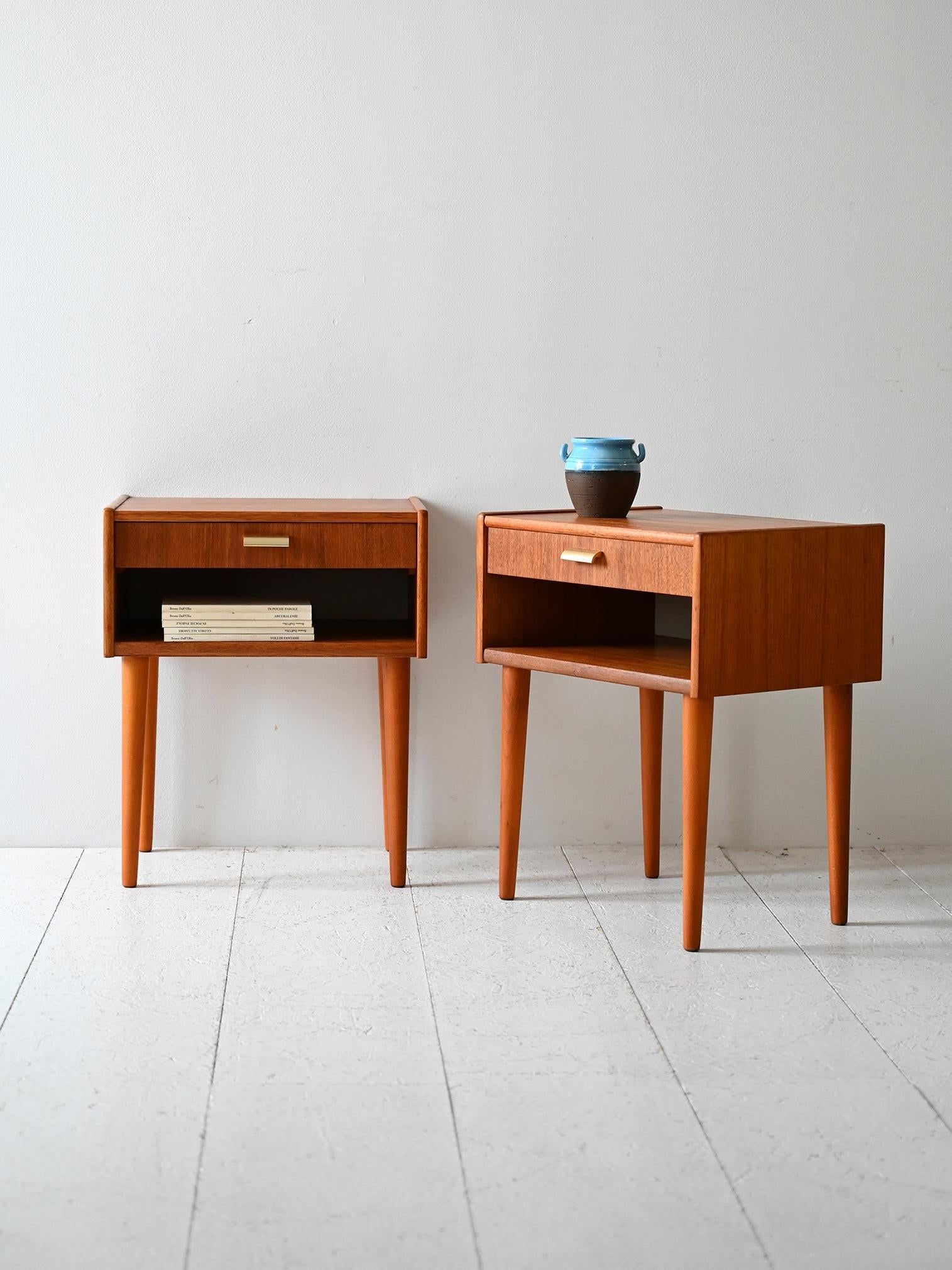 Coppia di comodini anni '50/'60 in teak, con cassetto, mensola aperta e gambe affusolate.

Elegante coppia di comodini scandinavi originali degli anni ’50/’60. Struttura in teak con gambe affusolate, cassetto con maniglia in ottone e vano a giorno