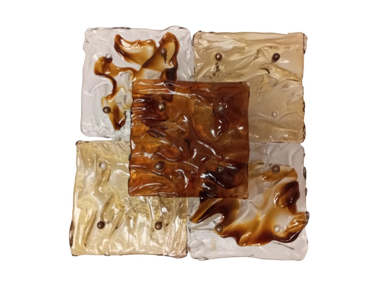 Sistema de iluminación de pared o techo compuesto por 2 elementos de cristal de Murano, modelo 'Patchwork', diseñado por Toni Zuccheri para Venini. La estructura es de metal pintado de blanco, sobre el que se fija vidrio ondulado transparente y de