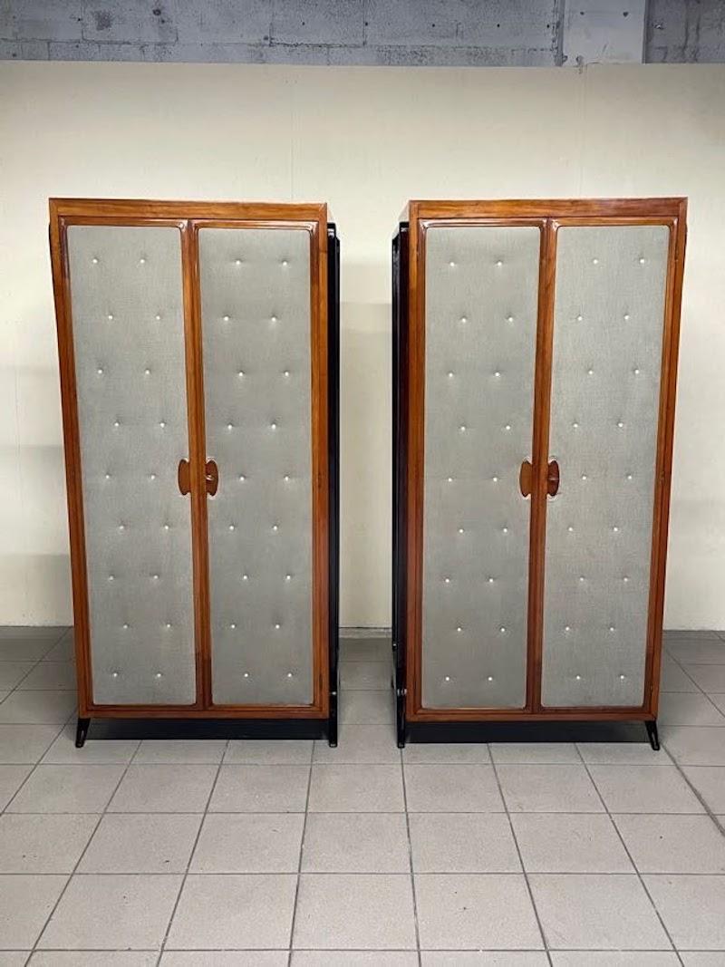 Coppia di armadietti degli anni '40 perfettamente restaurati.

La struttura è in legno di pero con sostegni esterni in legno tinto.
Il fronte delle ante è rivestito in tessuto con bottoni tipo madreperla.
Il rivestimento in tessuto è nuovo in quanto