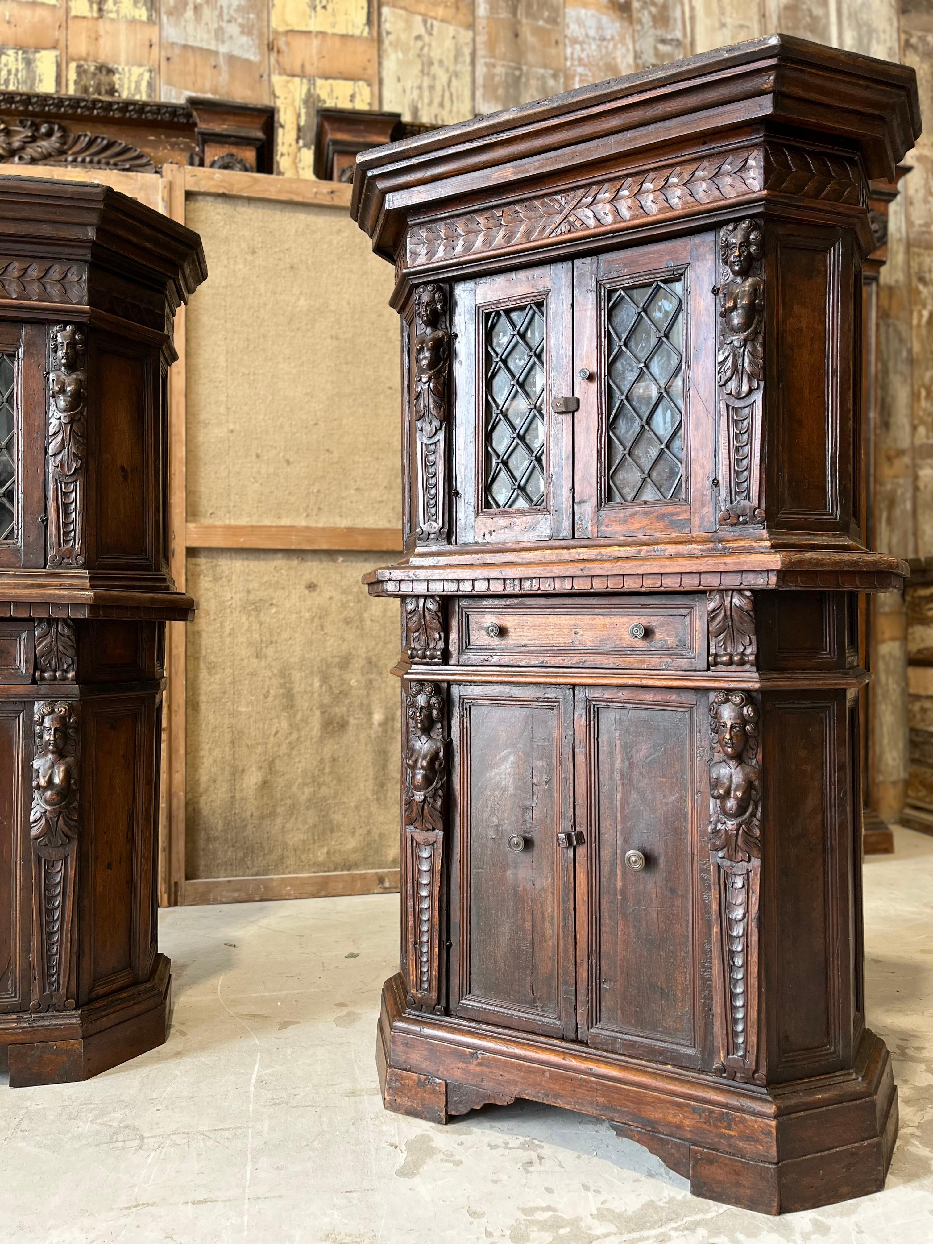 Coppia di piccole credenze neorinascimentali finemente intagliate a mano in legno di noce.
Questa preziosa coppia riccamente decorata con intagli floreali e figure femminili è  è stata realizzata a mano nella seconda metà del XIX secolo ed è stata