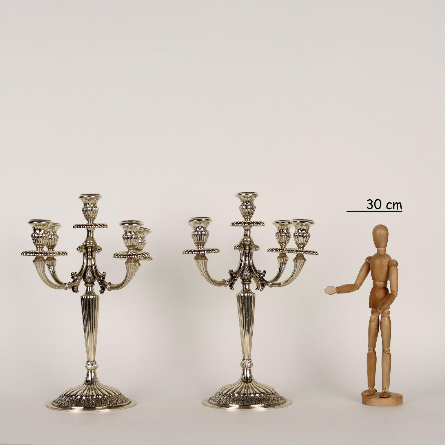 Paire de candélabres à cinq flammes en argent ciselé. Motifs répétés à la base et aux bras avec des volutes de feuilles. Marques d'argent gravées sous la base, orfèvre milanais non identifié. Grammes 2900.