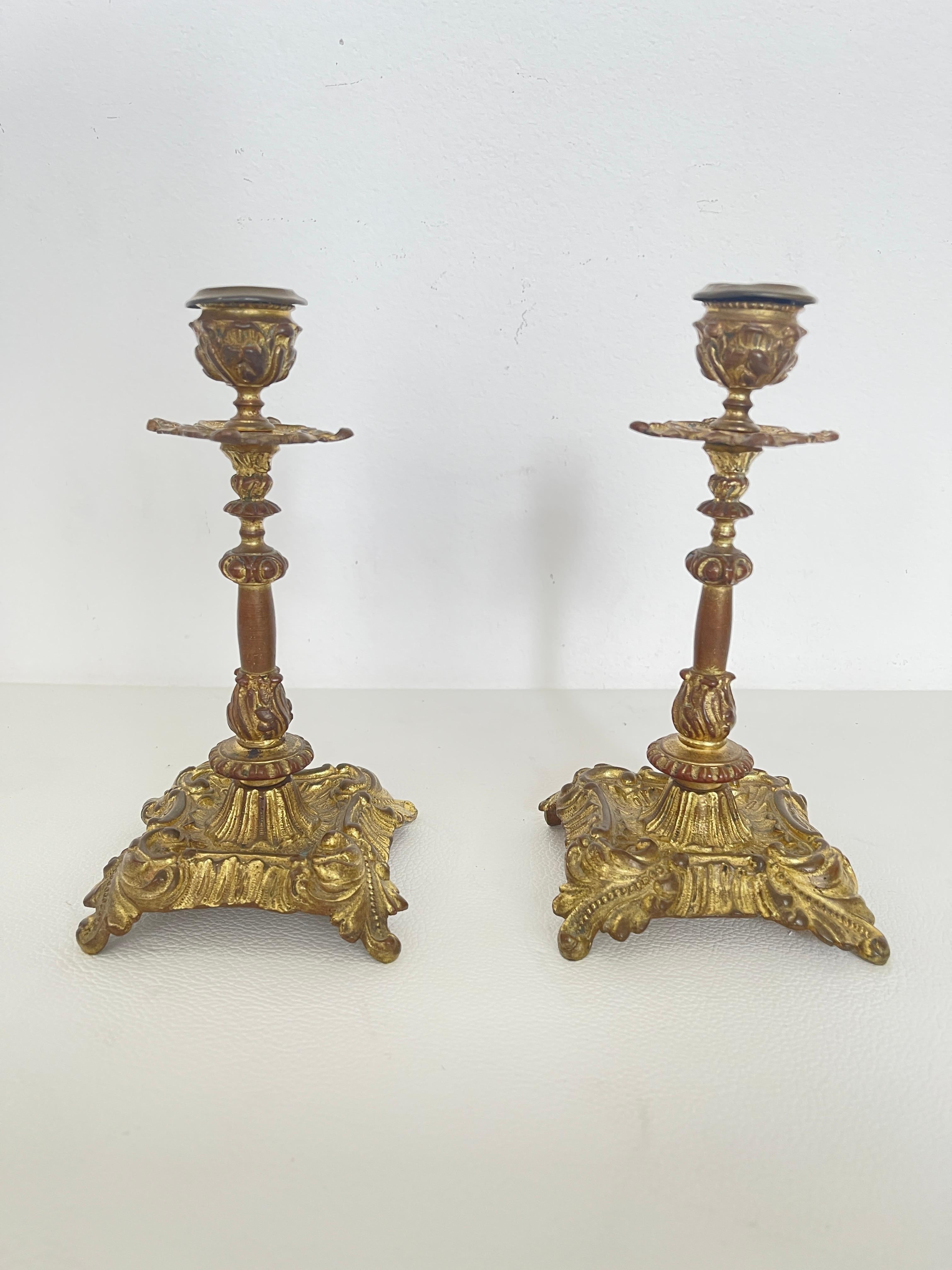 Gorgeous pair of finely crafted gilded bronze candelabra made in the classic Baroque style. The base is embellished with scrollwork and leaf motifs, while the tapered shaft alternates carved and smooth details with great harmony. The richly chiseled