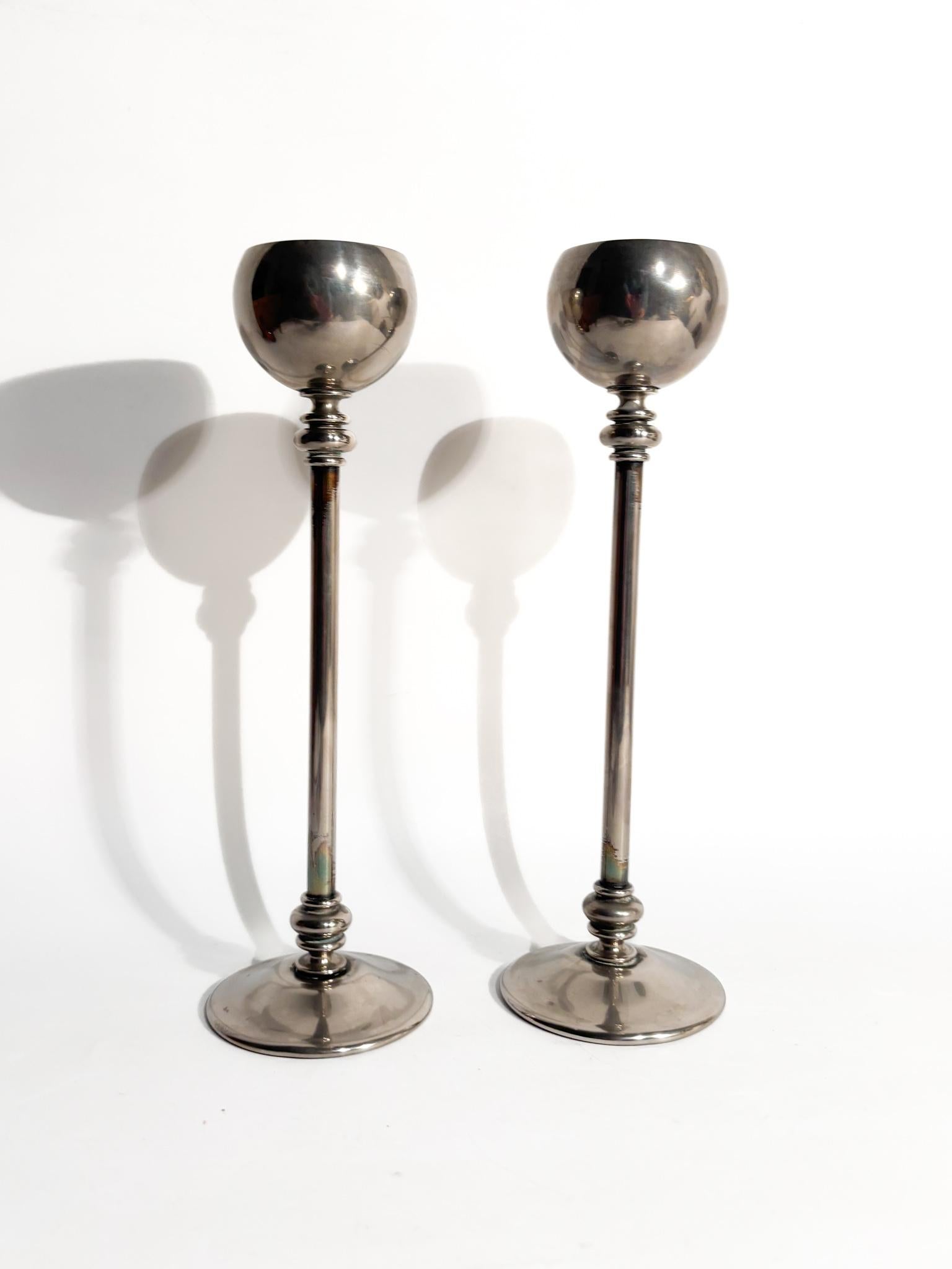 Coppia di candelieri in metallo argentato, realizzati negli anni '60

Ø cm 7 h cm 23