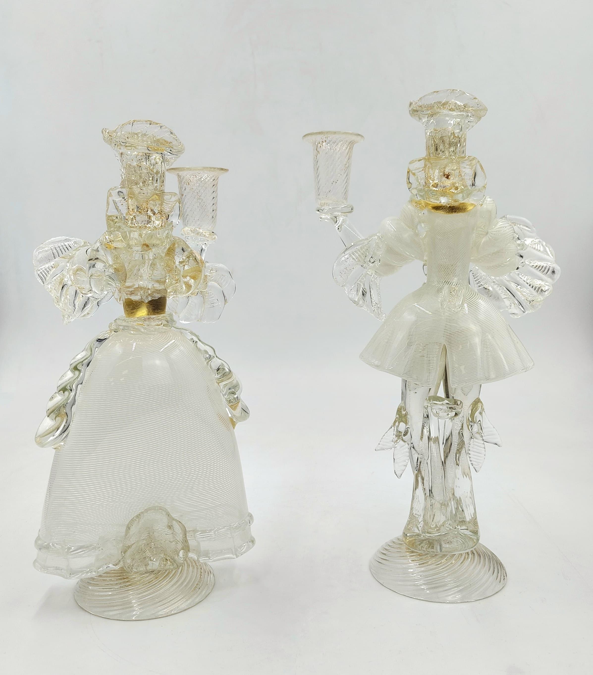 Pair of candelabra made around the 1980s from murano glass with gold dust. 
The two subjects represent a couple, Knight and Lady, wearing typical Venetian costumes. The male figure measures 32x18x10 cm and the female figure 30x14x9 cm. They were