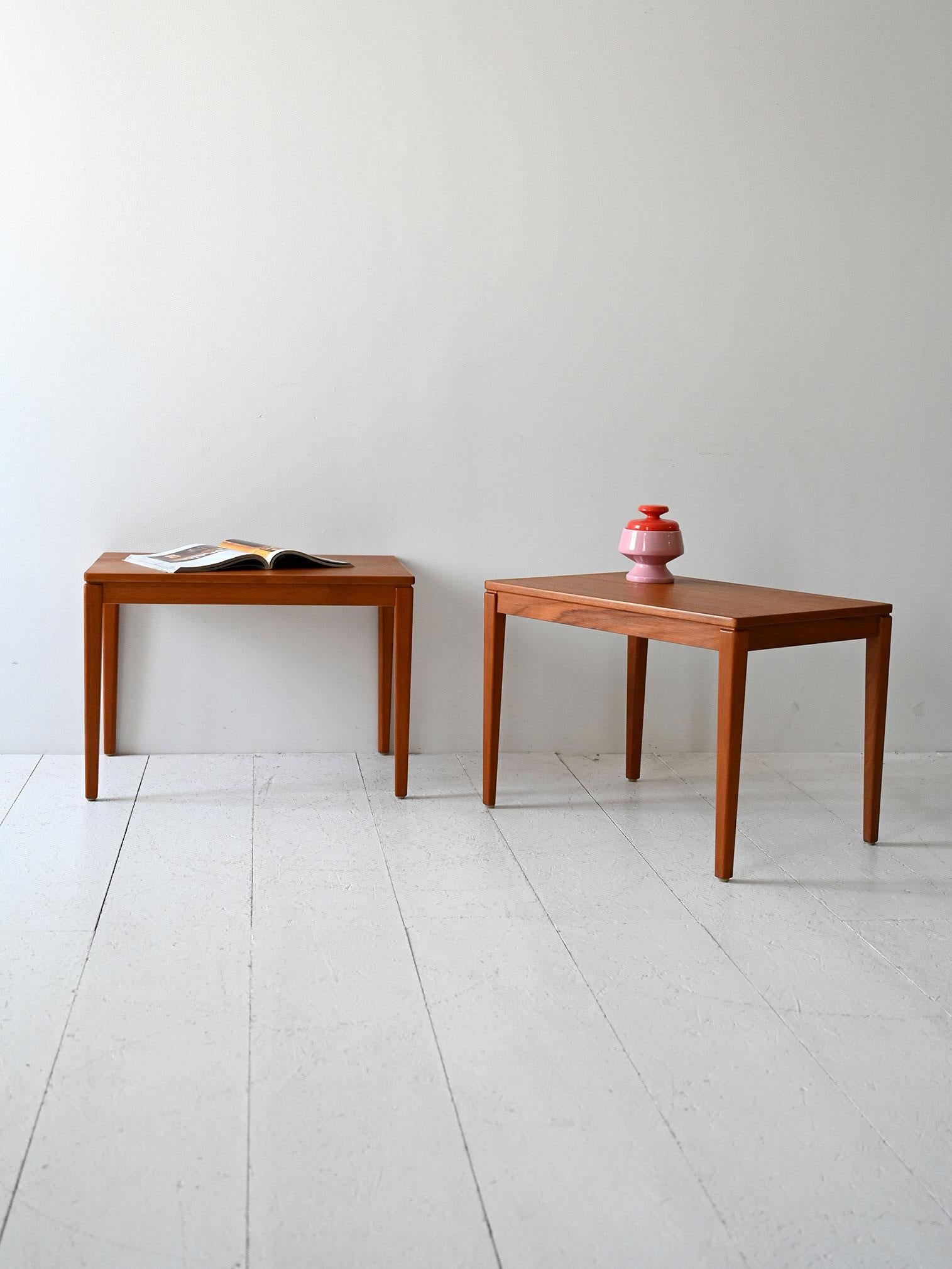 Coppia di tavolini in teak con linee squadrate, gambe affusolate e struttura solida ma visivamente leggera.

Coppia di coffee table scandinavi vintage, realizzati in teak con finitura calda e uniforme. Il disegno è essenziale e ben calibrato, con