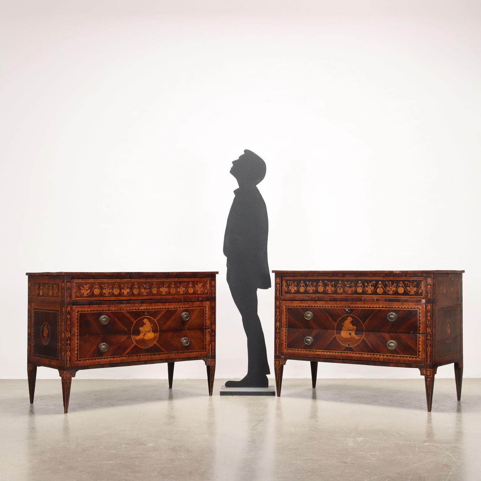 Coppia di comò neoclassici lombardi. Realizzati in noce e abete presentano sul fronte tre Cassetti ciascuno inserito nella fascia sotto piano e due più grandi senza catena a vista. Completamente impiallacciati in palissandro con bordure in bois de