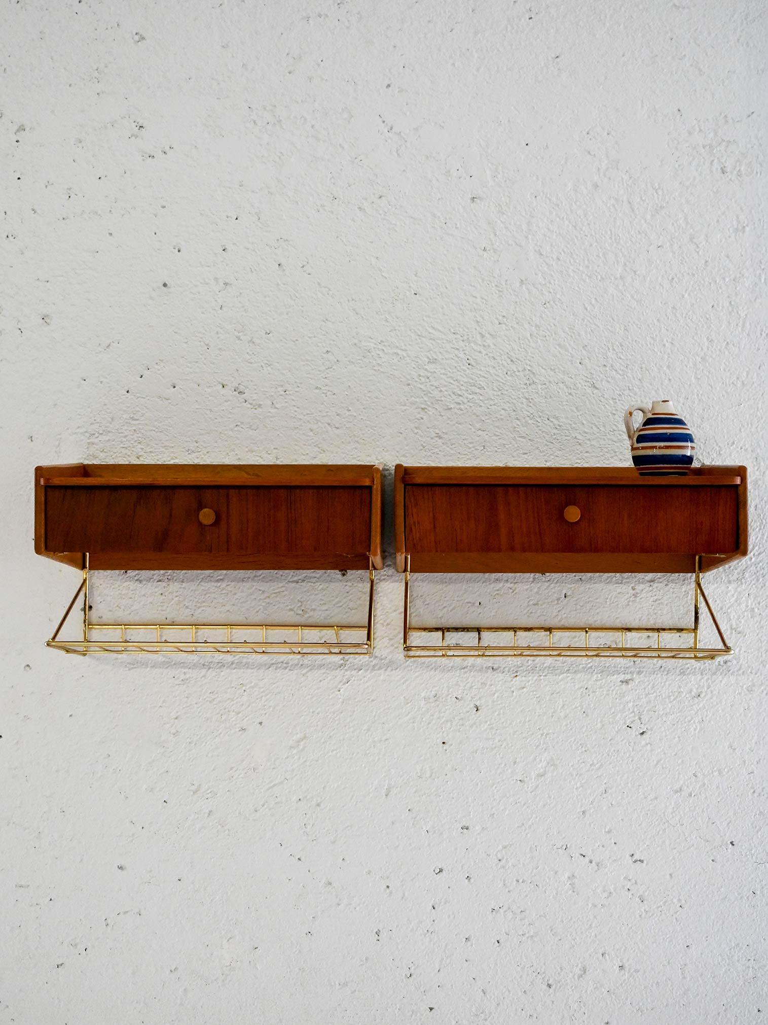 Paire de tables de chevet suspendues en teck avec cadre et tiroir en laiton. Design léger et géométrique, typique des années 1950.

Elégantes tables de chevet murales scandinaves des années 1950, en teck avec un tiroir intégré et un cadre en laiton