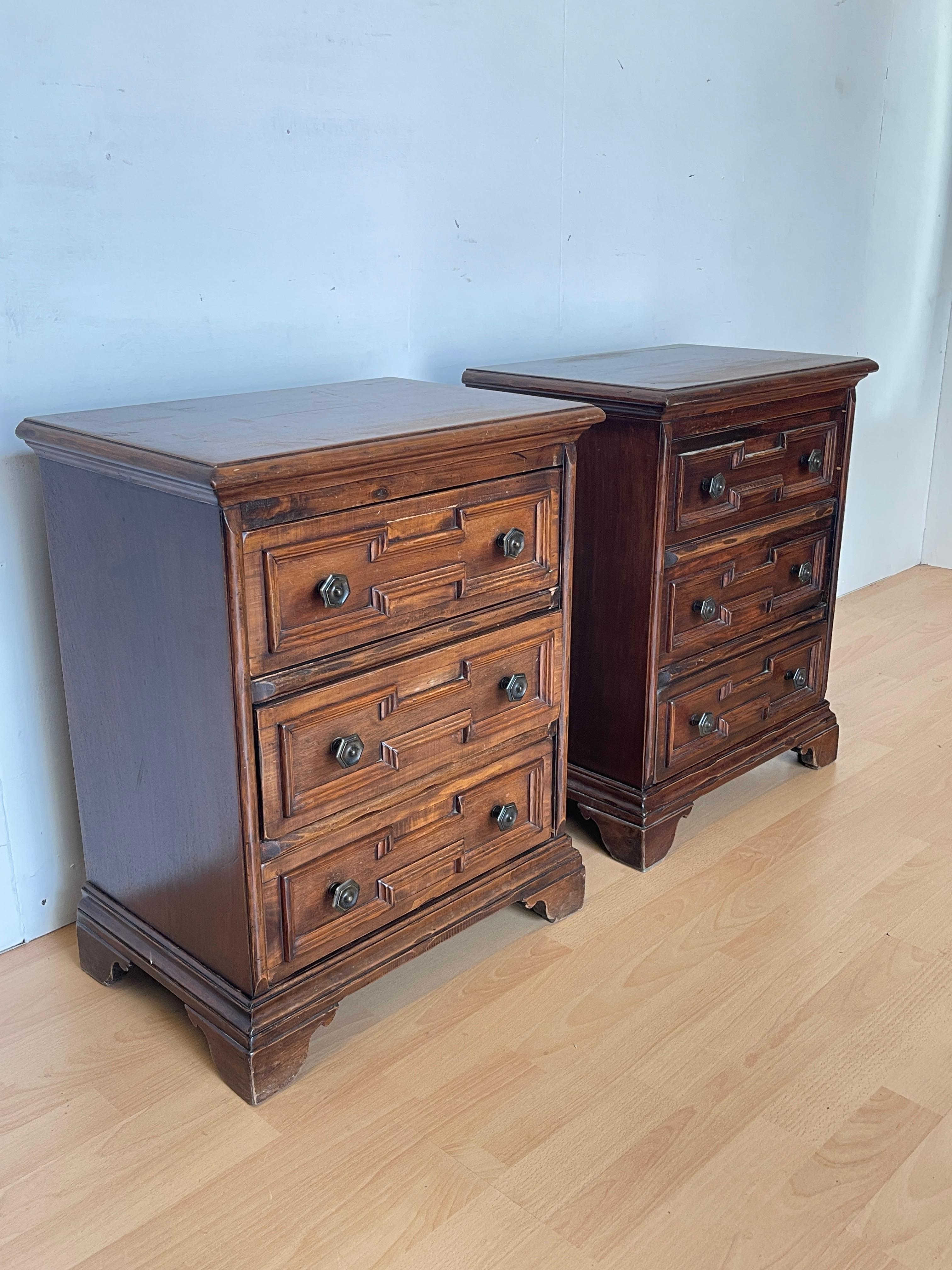 Élégante paire de tables de chevet en bois massif, caractérisée par un design classique et raffiné. Chaque table de chevet dispose de trois tiroirs avec des poignées en métal, parfaits pour organiser les objets personnels. Le bois noble a été traité