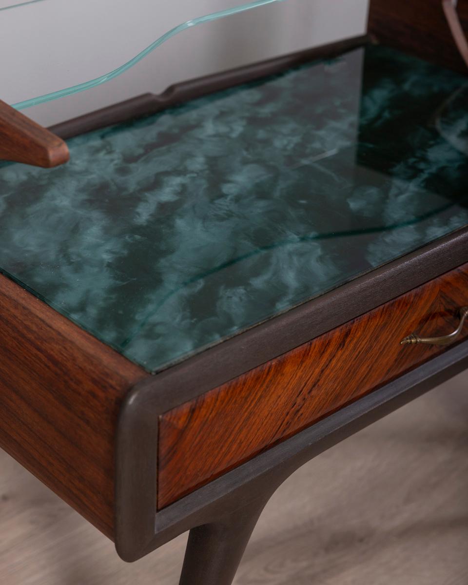 Coppia di comodini in legno con due ripiani in vetro, quello superiore trasparente e quello inferiore decorato in blu, cassetto con maniglia in ottone dorato, design italiano, anni '50.

CONDIZIONE:
En buenas condiciones, puede presentar signos de