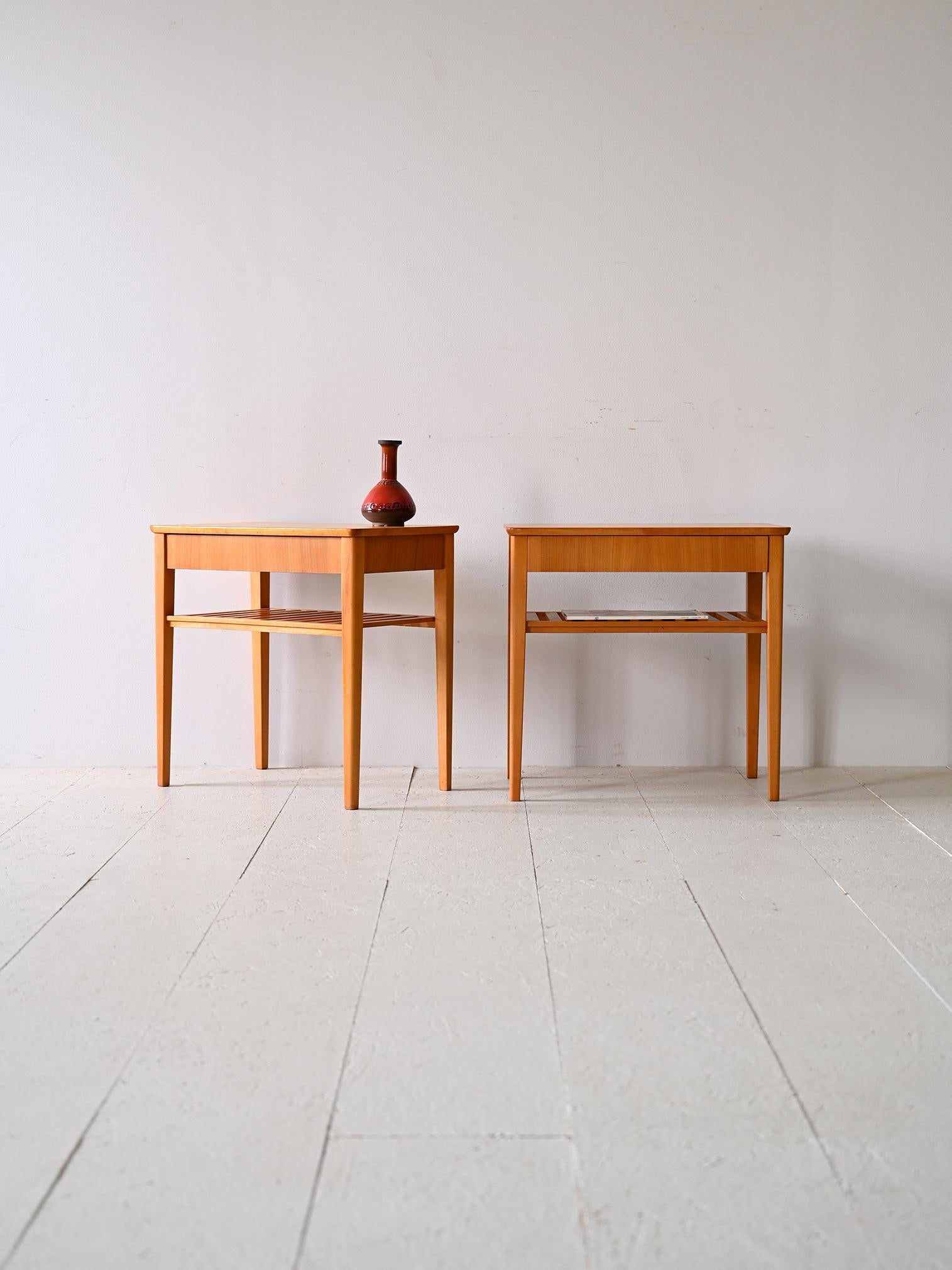 Coppia di tavolini / comodini scandinavi originali anni '60.

Eleganti e funzionali, questa coppia di comodini incarna lo stile nordico con linee estremamente semplici e pulite, caratterizzate da un design minimale e classico. Ogni comodino presenta