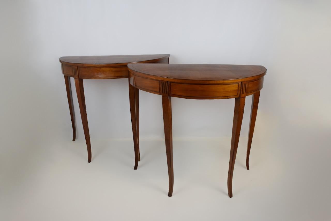 Zwei kleine, elegante halbmondförmige Konsolen aus Kirschholz, die sich durch eine nüchterne und elegante Ästhetik auszeichnen, die typisch für die Zeit des Directoire ist  (Anfang des 19. Jahrhunderts).
Abmessungen: Breite   92 cm, Tiefe 49 cm, 