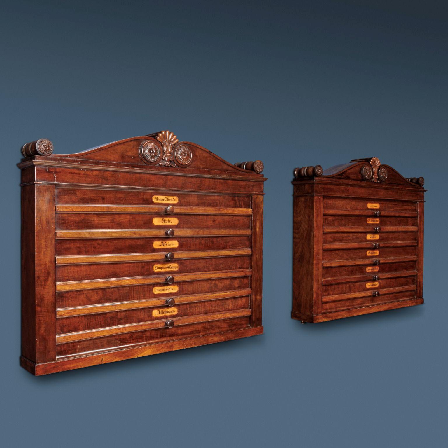 Pair of poplar wall cabinets veneered in mahogany, each with six pull-out drawers with maps signed 