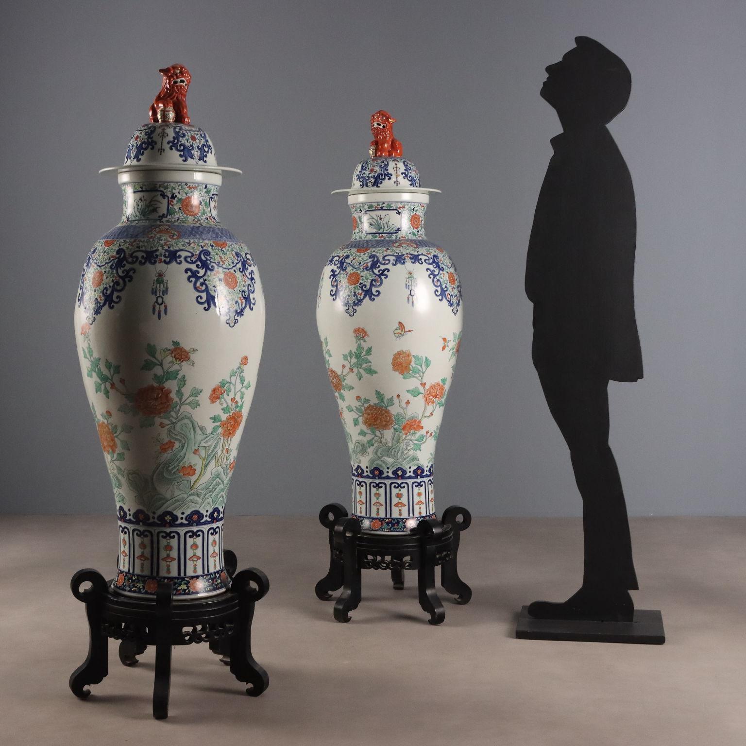 Coppia di grandi vasi a balaustro con coperchio, decorate nella parte centrale del corpo con piante fiorite di peonia su rocce ornamentali, ricca decorazione a ramemi vegetali fogliati sul collo e sul coperchio con presa a cani di fo. Soporte de