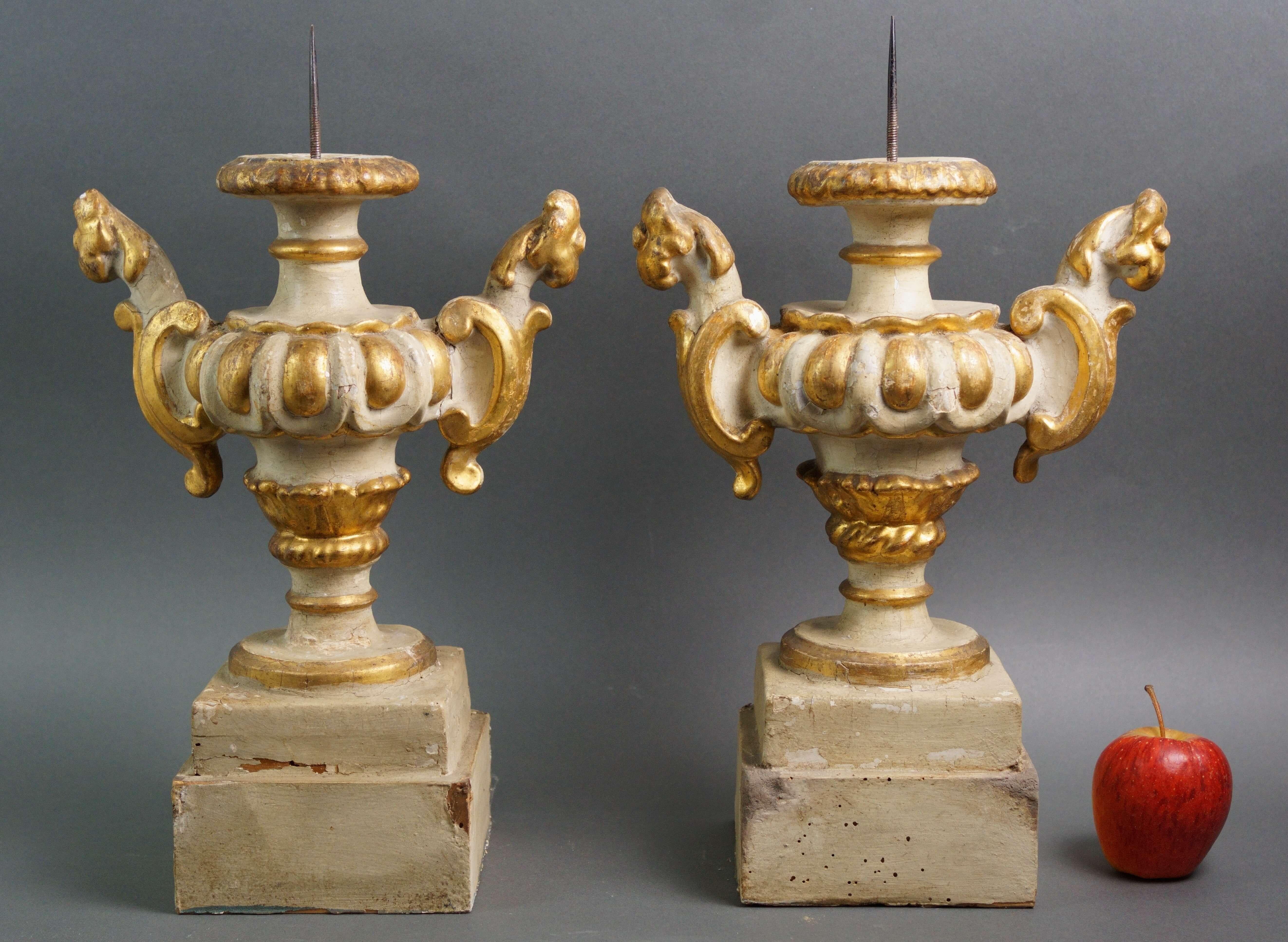 Coppia di imponenti reggipalme barocchi in legno scolpito, laccato e dorato a foglia, Italia, prima metà del XVIII secolo. Raffinato lavoro di scultura in cui i due portacero assumono la forma di un vaso con grandi manici intagliati a forma di testa