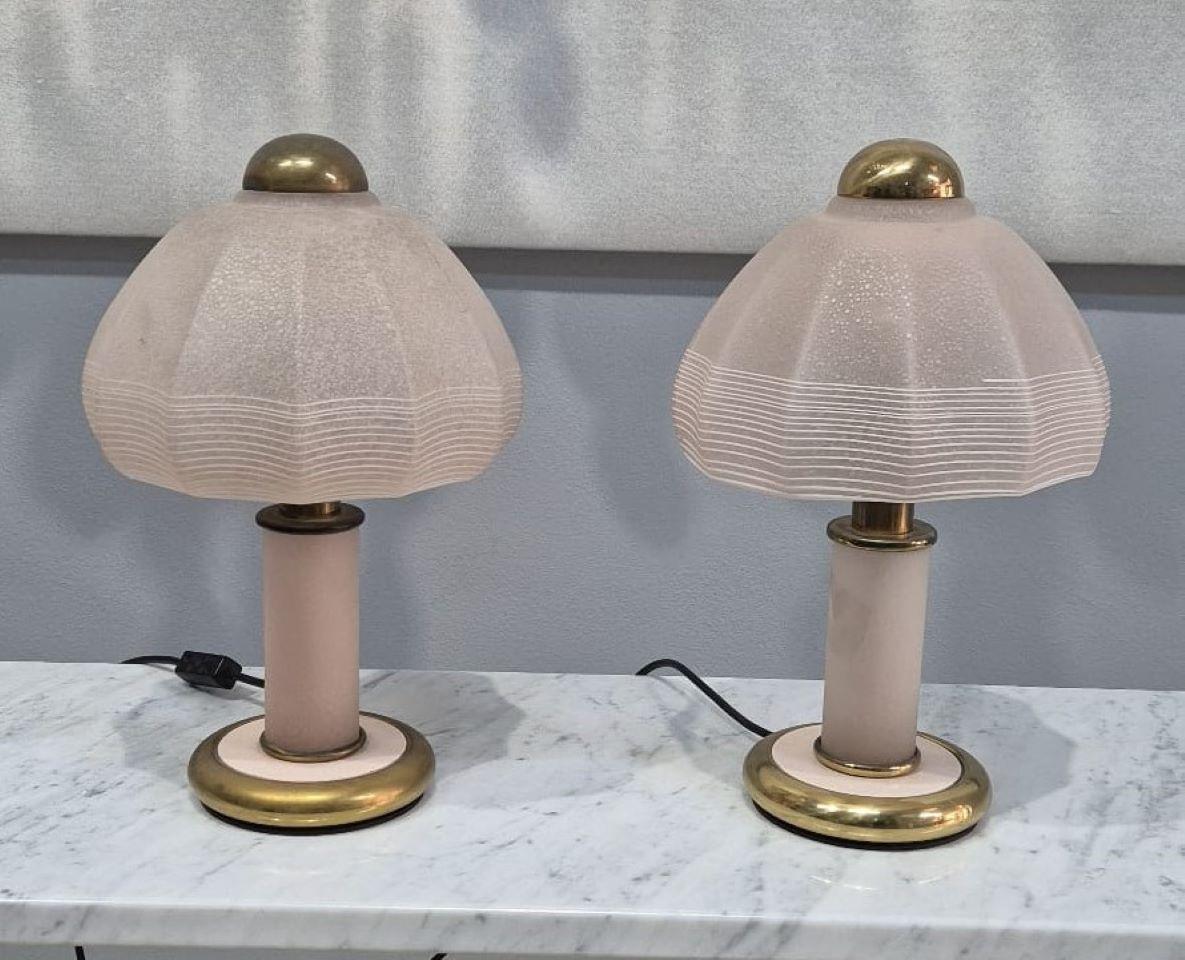 coppia di lampade da tavolo in vetro di Murano di F. Fabbian, anni '70.
Paralume in vetro di murano rosa tenue, la struttura in metallo adornata da inserti color oro. Le lampade si presentano in buone condizioni, con qualche segno di usura dati dal