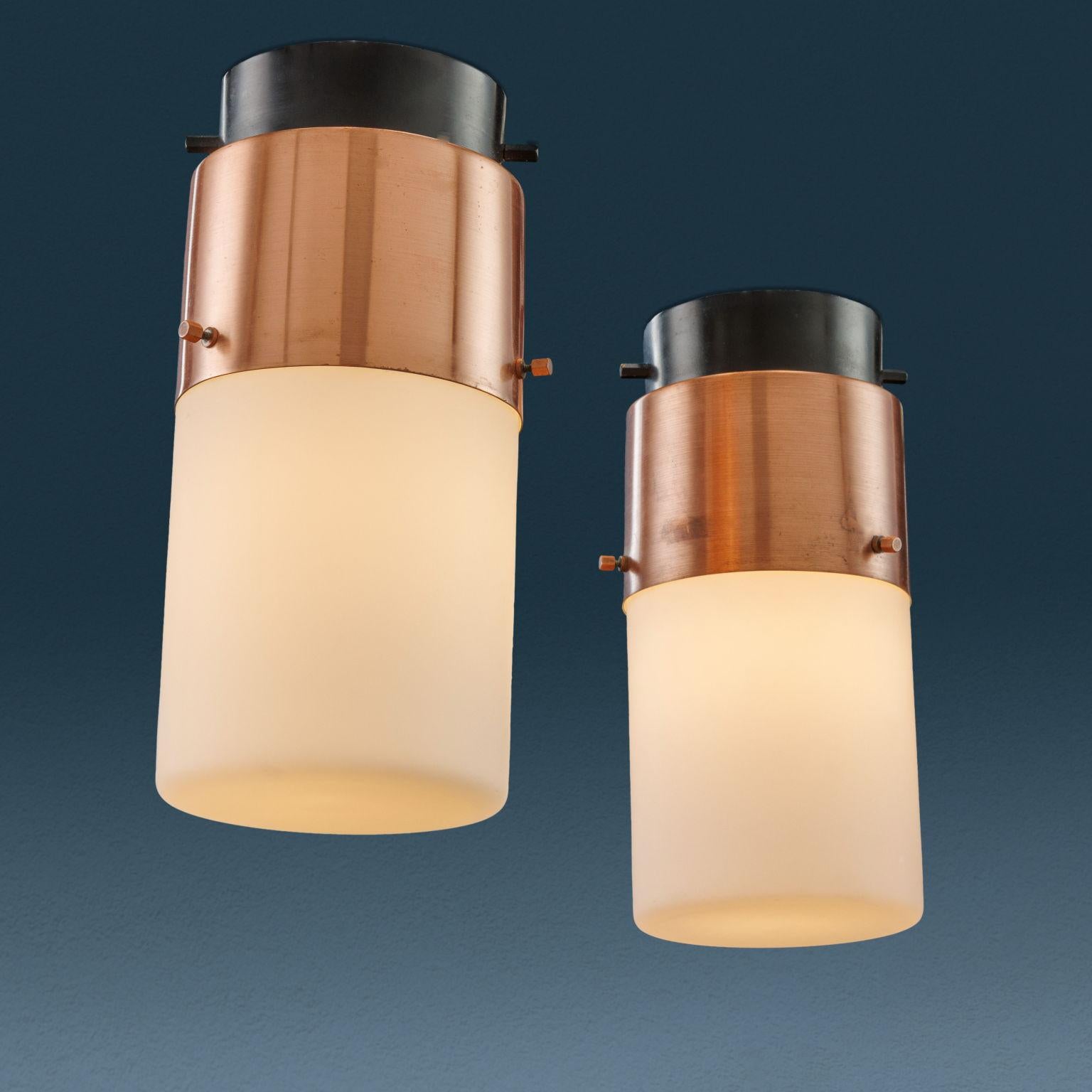 Due lampade a plafone Stilnovo modello '1245', realizzate negli anni '60.
In rame spazzolato, alluminio laccato e vetro 'Triplex opal' satinato.

In ottime condizioni originali, riportano il marchio della produzione.