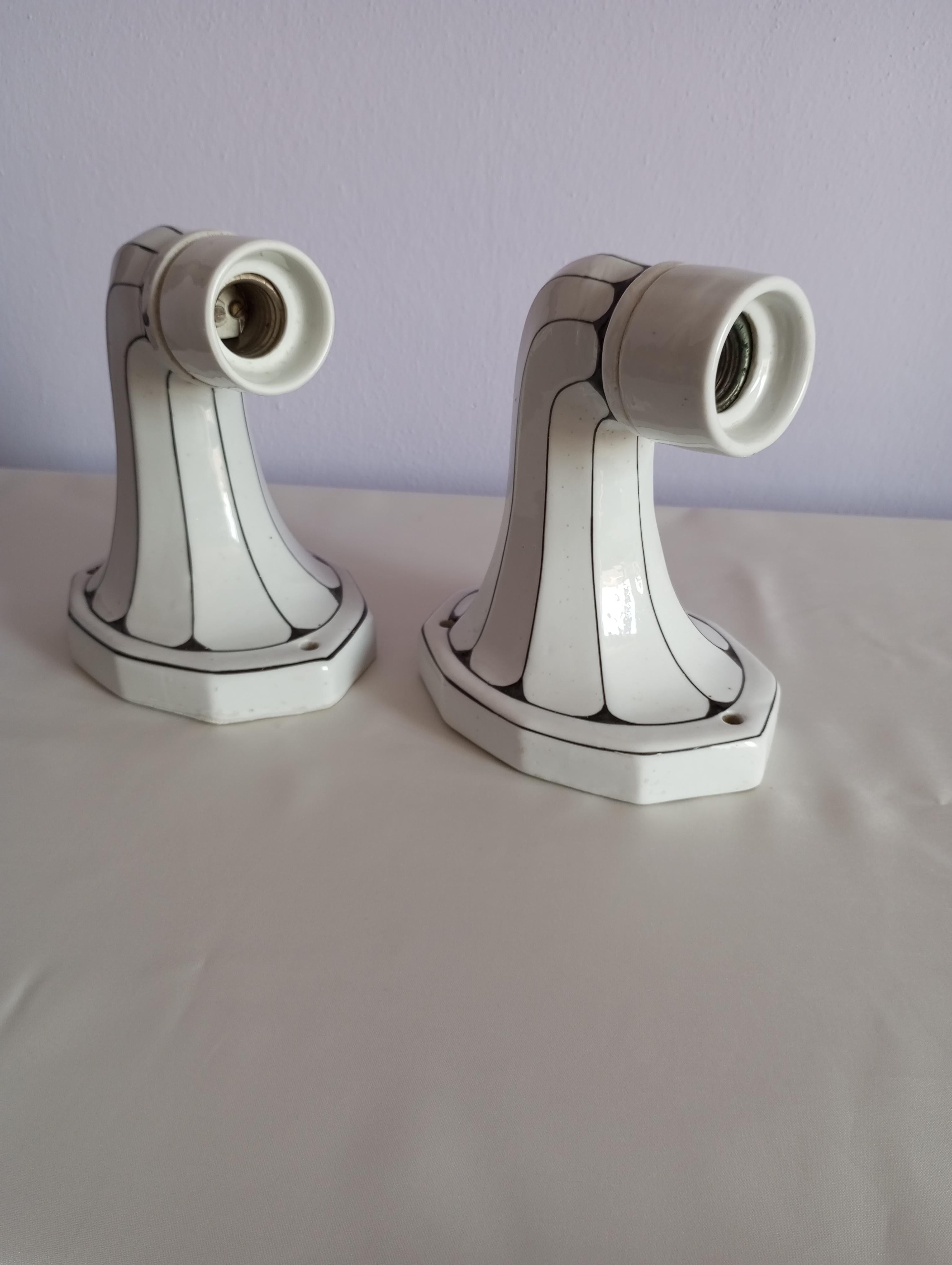 Queste appliques da parete, realizzate negli anni '60, rappresentano un elegante esempio di stile Art Nouveau, con il loro braccio in porcellana smaltata caratterizzato da una raffinata combinazione di bianco e nero. L'armonia dei colori, unita alla