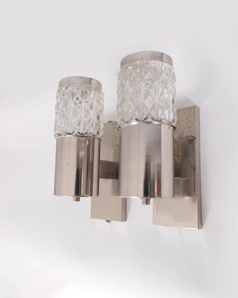 Coppia di lampade da parete in metallo cromato con paralumi in vetro, disegnate da Targetti, anni '70.

CONDIZIONE:
En buen estado, funcional, puede presentar signos de uso debidos a la edad.

DIMENSIONES 
Altezza 21 cm; Larghezza 7 cm; Profondità