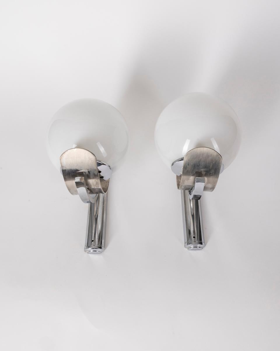 Pair of wall lamps with chrome metal frame and white glass shades, Italian design, 1980s.

CONDITION:
In good, working condition, may show signs of wear given by time.

SIZING: 
Height 31 cm; width 15 cm;  Length 22 cm;  

MATERIALS: 
Metal and