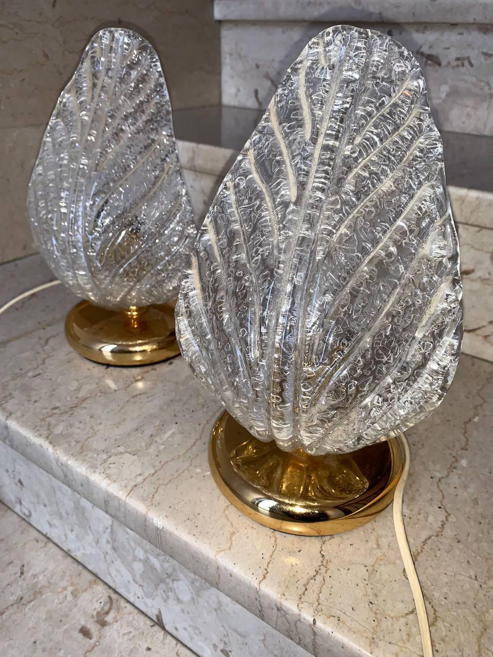 Charming pair of Murano art glass wall sconces from the 1980s  '90 with classic Venetian grit work.  Each lamp consists of a  lampshade made of transparent glass molded in the shape of leaves and features an extraordinary light effect, achieved