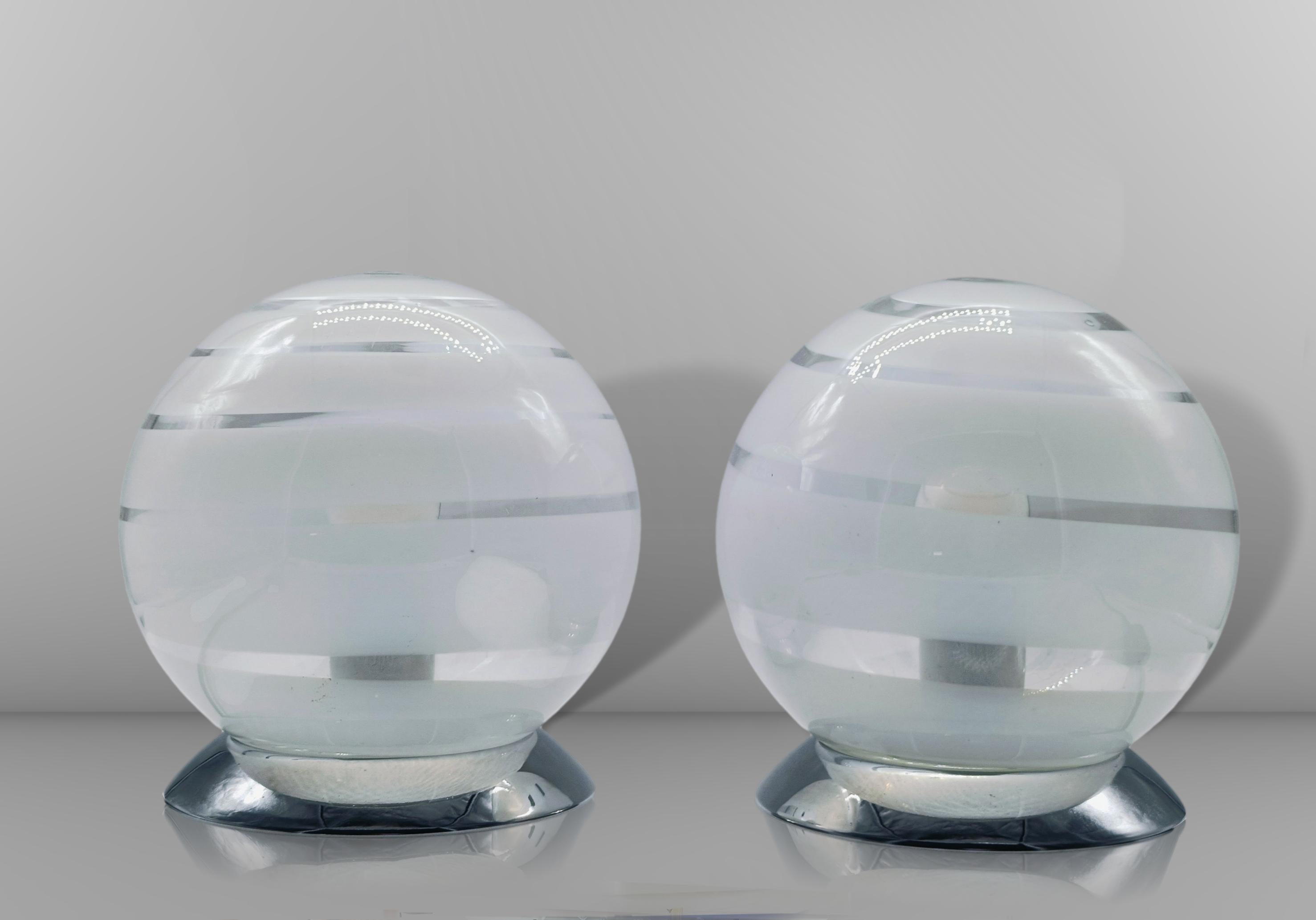 Belle paire de lampes de table dans le style de Tony Zuccheri avec base circulaire en métal chromé et abat-jour circulaire en verre de Murano avec des nuances blanches.