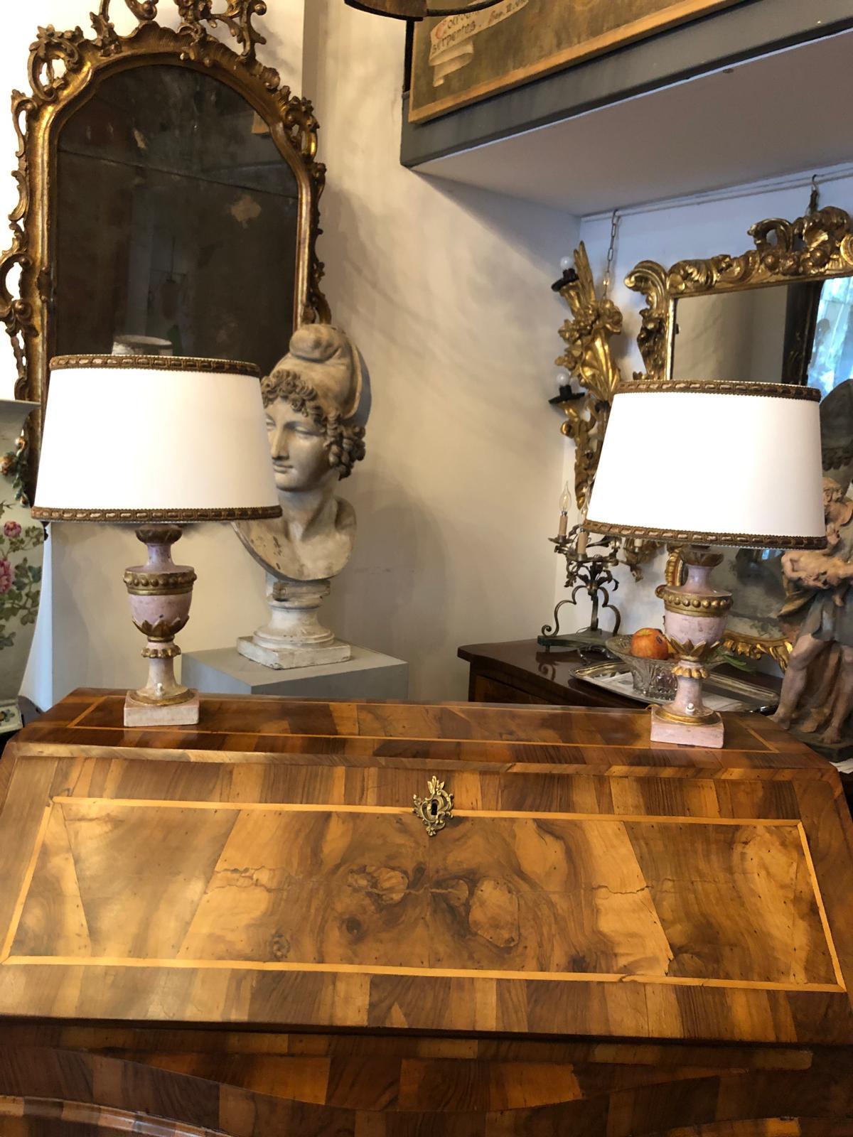 Paar italienische Empire-Lampen 1800 Lackierte Holzvasen in Rosa und Gold   mit einem ovalen Lampenschirm, die Sockel sind zwei antike Palmenhalter, die in zarten Rosatönen lackiert sind. Der Körper des Palmenhalters ist kreisförmig mit vergoldeten