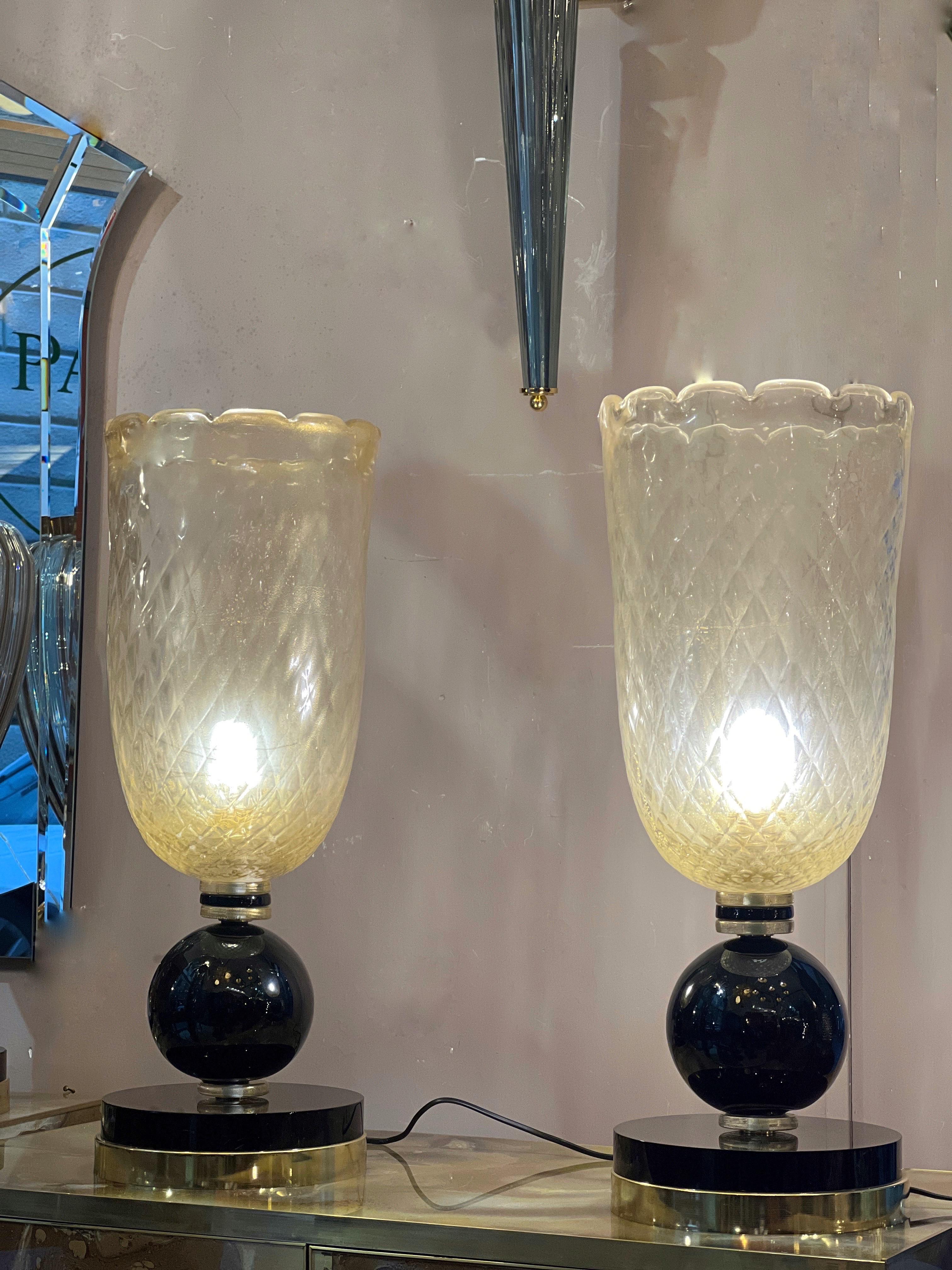 Coppia di lampade in vetro di Murano oro a coppa, con base nera rotonda. Il vetro della coppa è soffiato con l'oro zecchino e smerlato nei bordi
Una lampadina per lampada.
