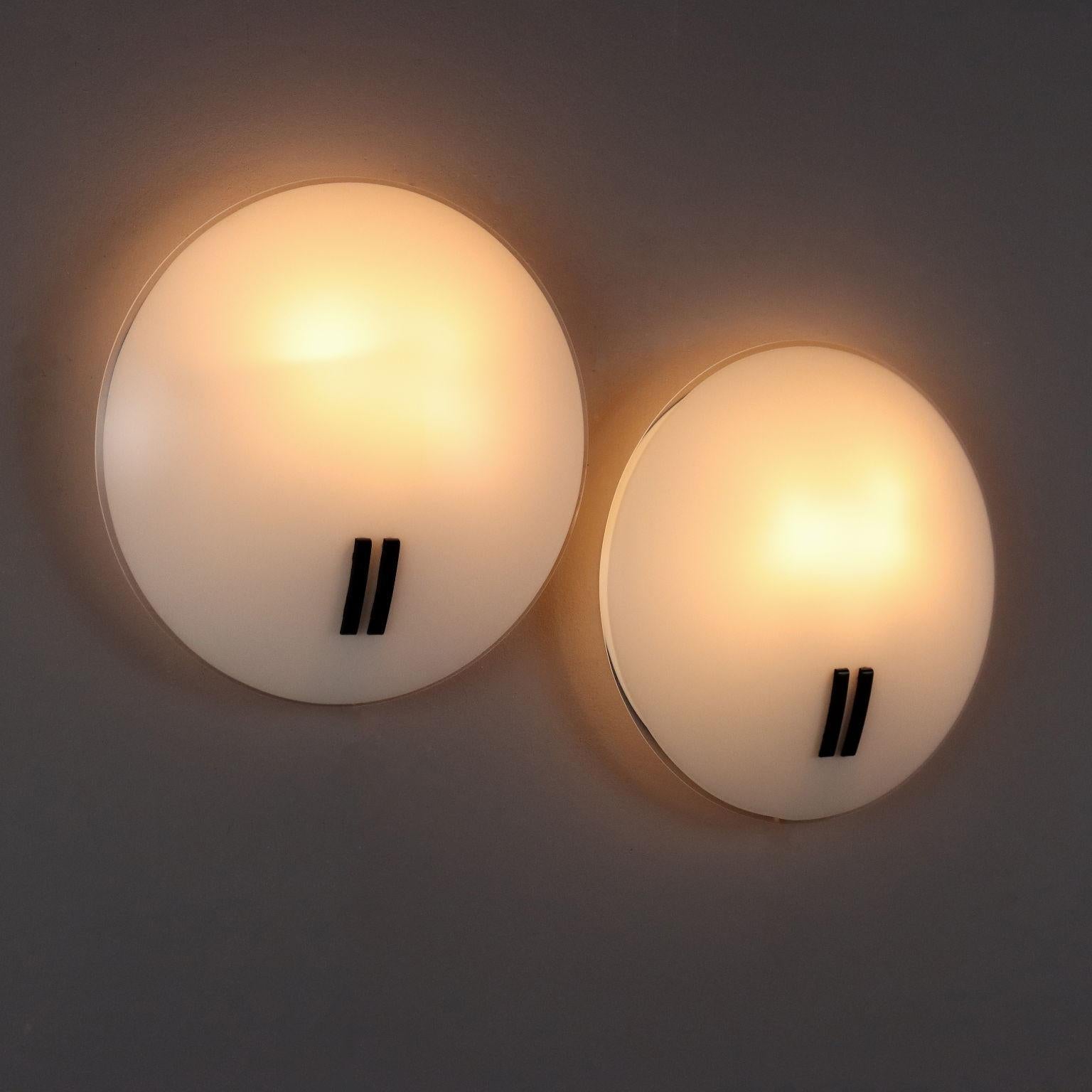 Coppia di lampade a parete, montatura in alluminio smaltato, vetro bianco. 