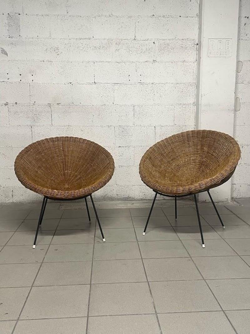 Pair of 1950s armchairs made of woven wicker and enameled tubular metal frame with white-colored ferrule.

Comfortable, cozy and fascinating because of the material they are made of.

In good condition, no problems are evident in the structure.