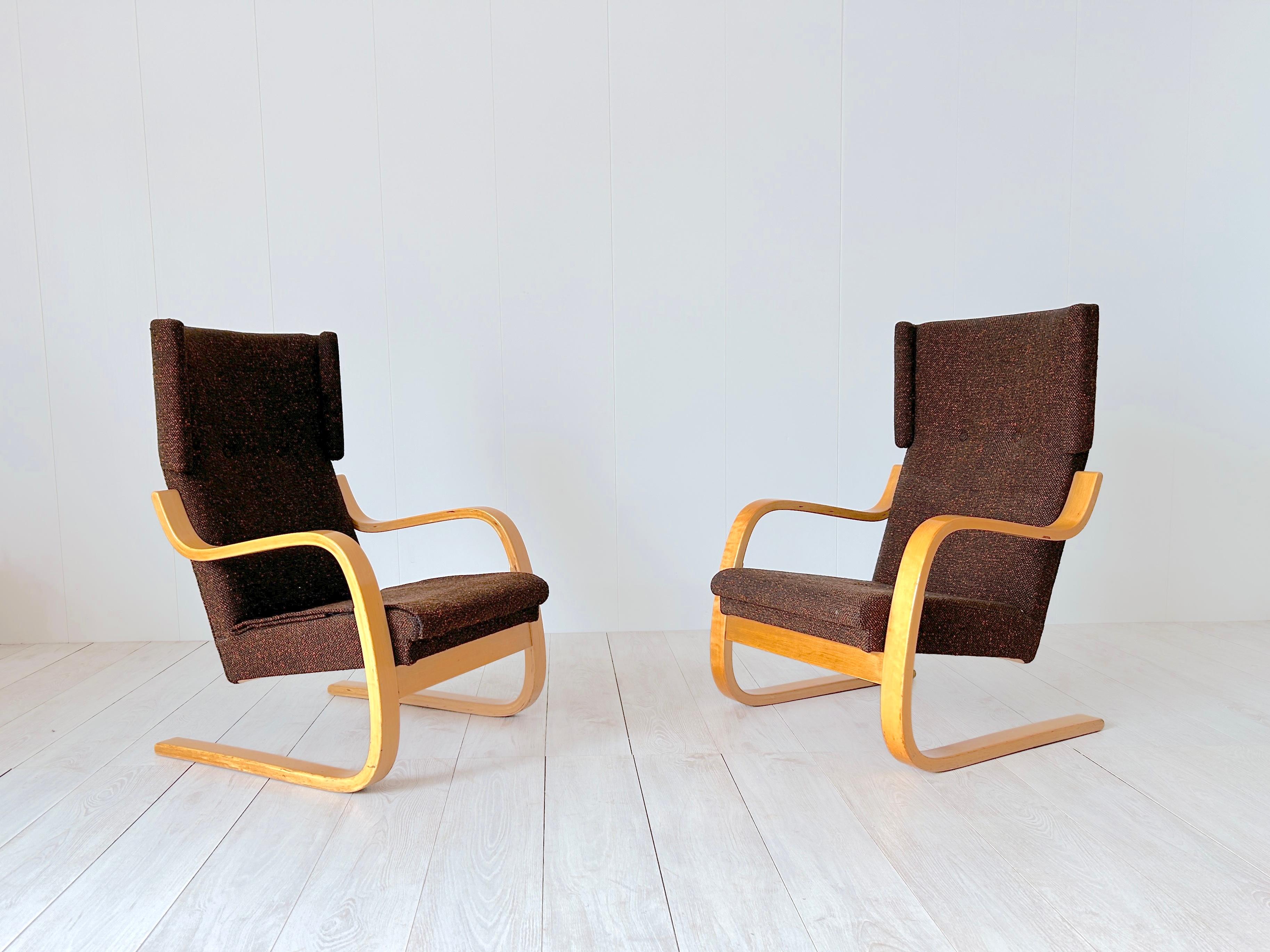 Questa coppia di poltrone modello 401 è stata disegnata da Alvar Aalto per Artek, Finlandia, 1933.  La struttura è in multistrato di betulla e con tessuto vintage marrone (piccoli difetti) Questa versione delle sedie è stata prodotta negli anni '70