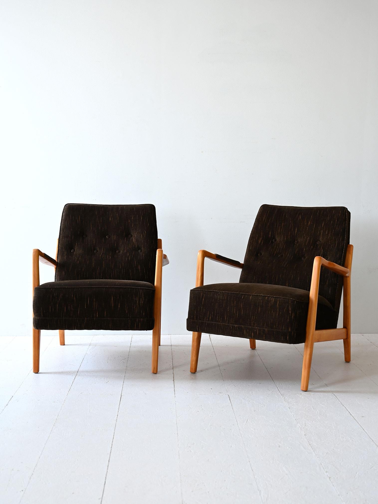 Fauteuils scandinaves des années 1960 avec structure et accoudoirs en bois et assise recouverte d'un tissu d'époque. 

Des lignes modernes et une assise confortable caractérisent ces élégants fauteuils de style rétro. 
Bon état. Il peut présenter