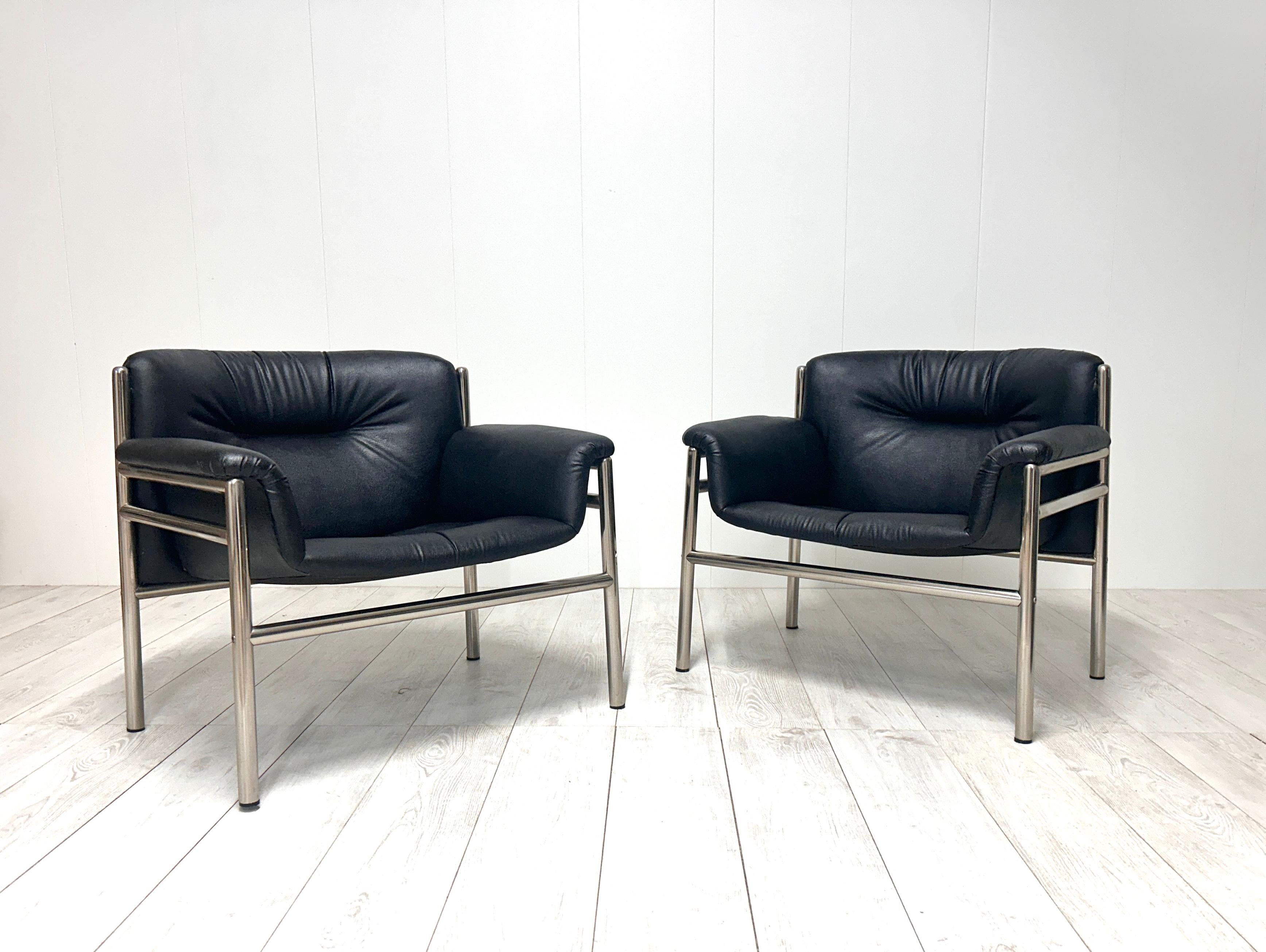 Curieuse paire de fauteuils avec structure en acier tubulaire, assise et dossier en cuir noir. 
Bon état général.
