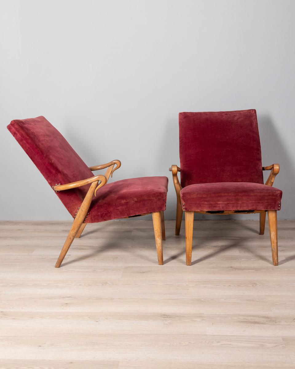 Coppia di poltrone con struttura in legno e rivestimento in velluto bordeaux, design Italiano, anni 50.

CONDIZIONI:
In buone condizioni, presentano segni d'usura dati dal tempo.

DIMENSIONI: 
Altezza 84 cm; Larghezza 70 cm;  Lunghezza 90 cm; 