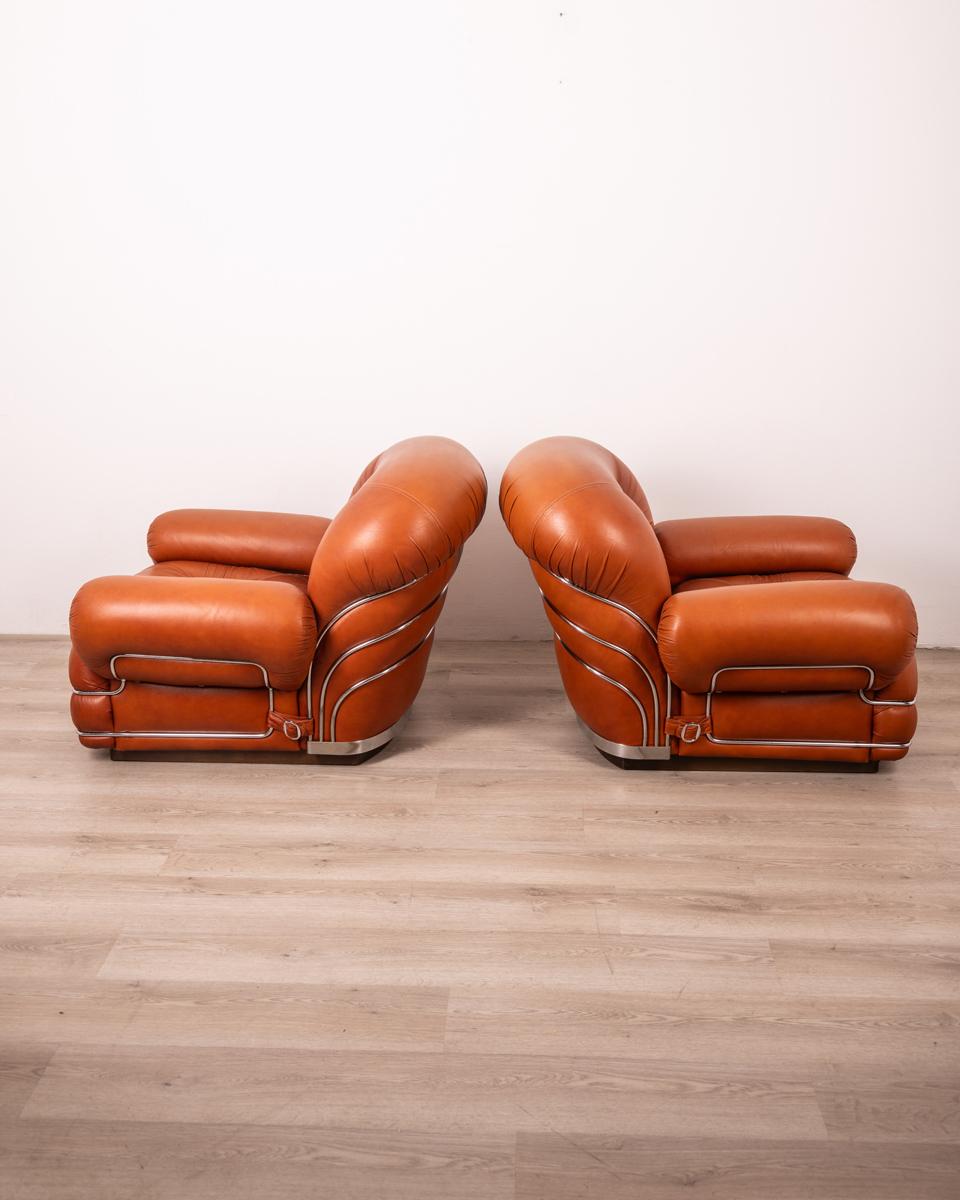 Paire de fauteuils avec base en bois, structure en acier chromé et revêtement en cuir marron, années 1970, design italien.

ÉTAT : En bon état, peut présenter de légers signes d'usure au fil du temps.

DIMENSIONS : Hauteur 72 cm ; Largeur 90 cm ;