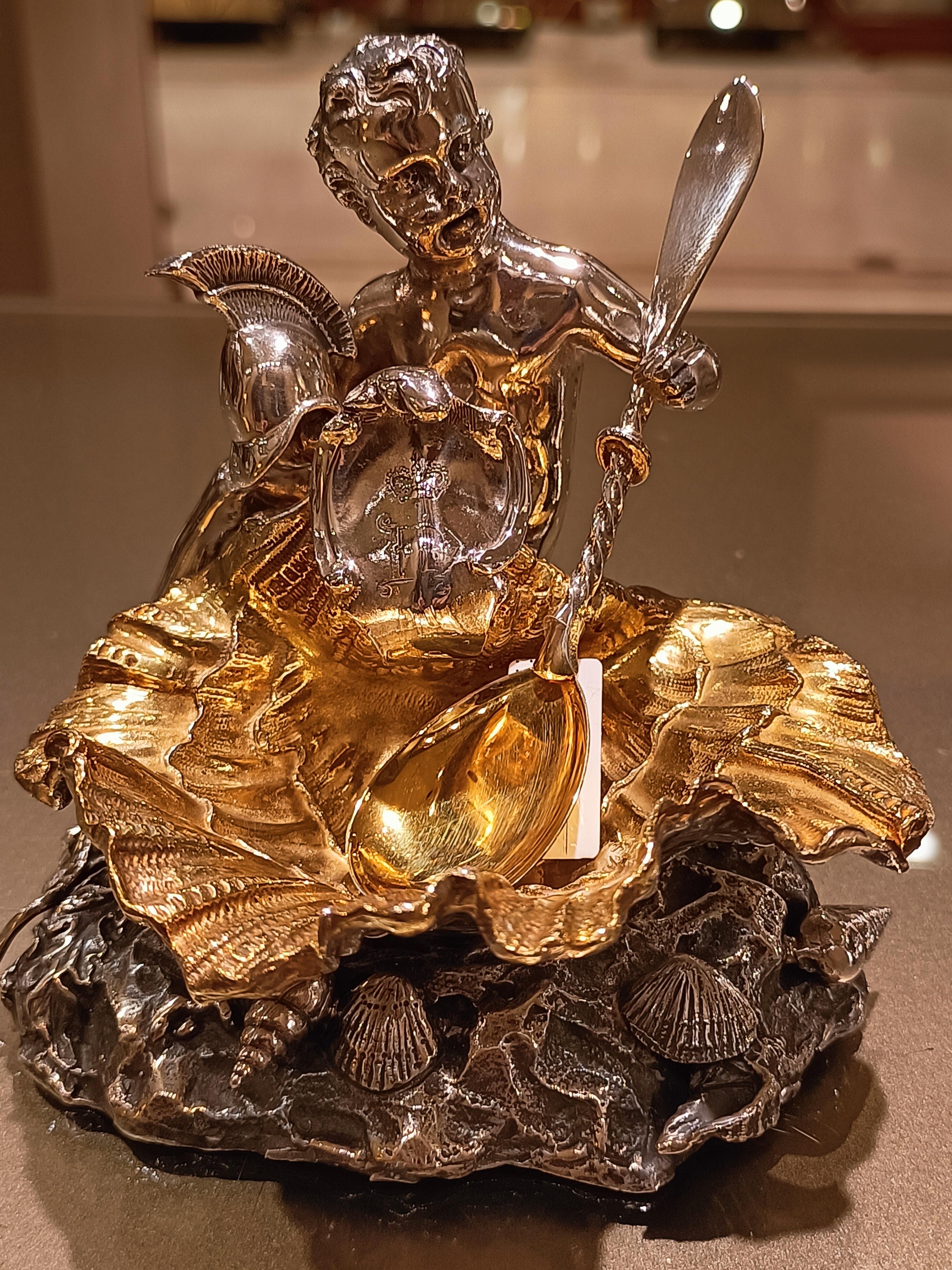 Important pair of silver salt shakers made of solid silver by Italian manufacture. The structure of the salt shaker consists of a base supporting a shell held by a putto with a helmet and an engraved scroll. Decorative apotropaic elements, such as