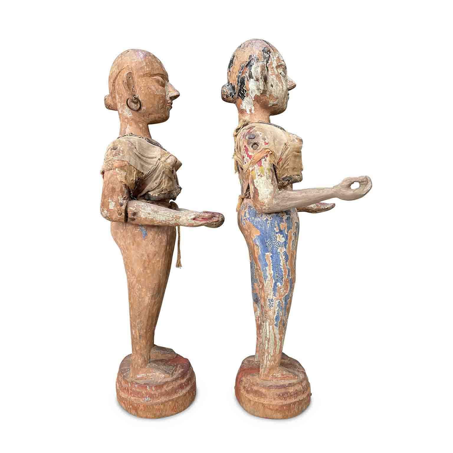 Paire de sculptures féminines de l'Asie ancienne,  figurines indonésiennes de la fin des années 1700 représentant deux femmes en bois sculpté et laqué à la main avec d'importantes taches de couleur qui leur confèrent un charme d'époque. Reposant sur