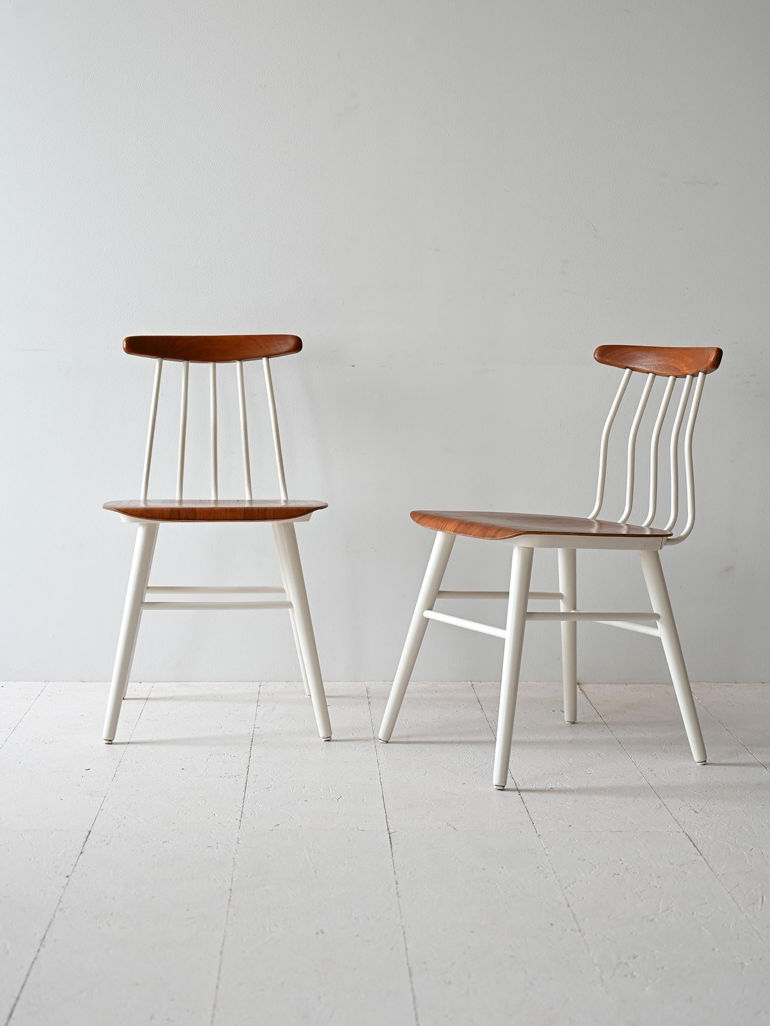 Lot de 2 chaises scandinaves des années 1960 avec assise en bois moulé et structure en bois peint en blanc.

La particularité de ces chaises est le dossier composé de fines tiges verticales légèrement incurvées, qui leur confère un aspect aérien et