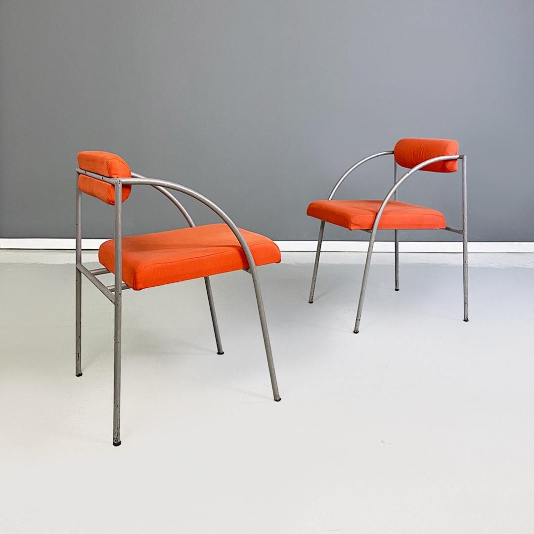 Pair of Vienna model chairs or armchairs with a frame with curved-profile arms made of round-section metal with a matte gray finish, upholstered back and seat covered in their original orange cotton fabric.
Designed by Rodney Kinsman and