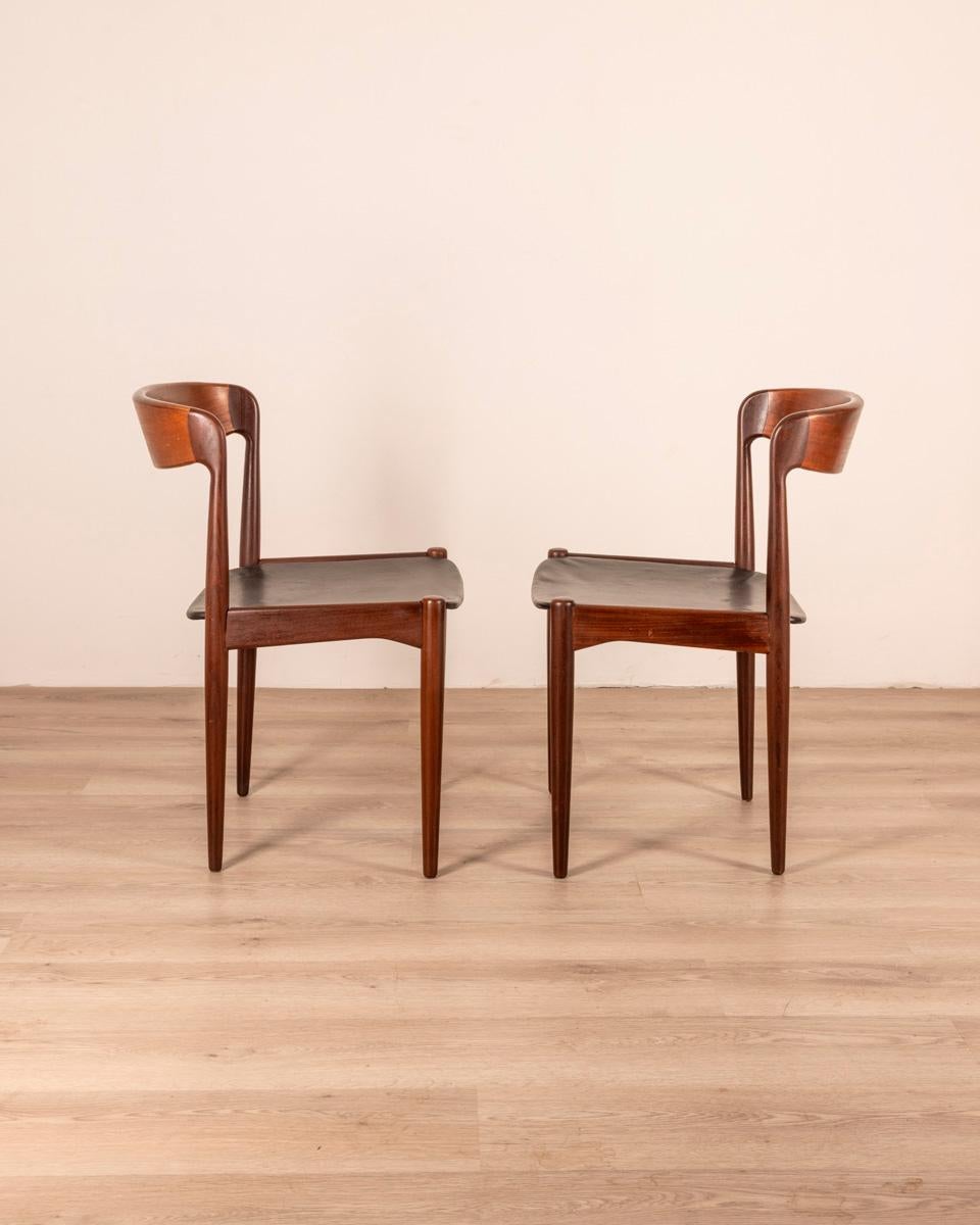 Paire de chaises danoises en teck avec assise en cuir noir, design Arne Hovmand Olsen, années 1950.

ÉTAT : En bon état, avec des signes d'usure dus au temps.

DIMENSIONS : Hauteur 78 cm ; Largeur 48 cm ; Longueur 48 cm ;

MATÉRIEL : bois et