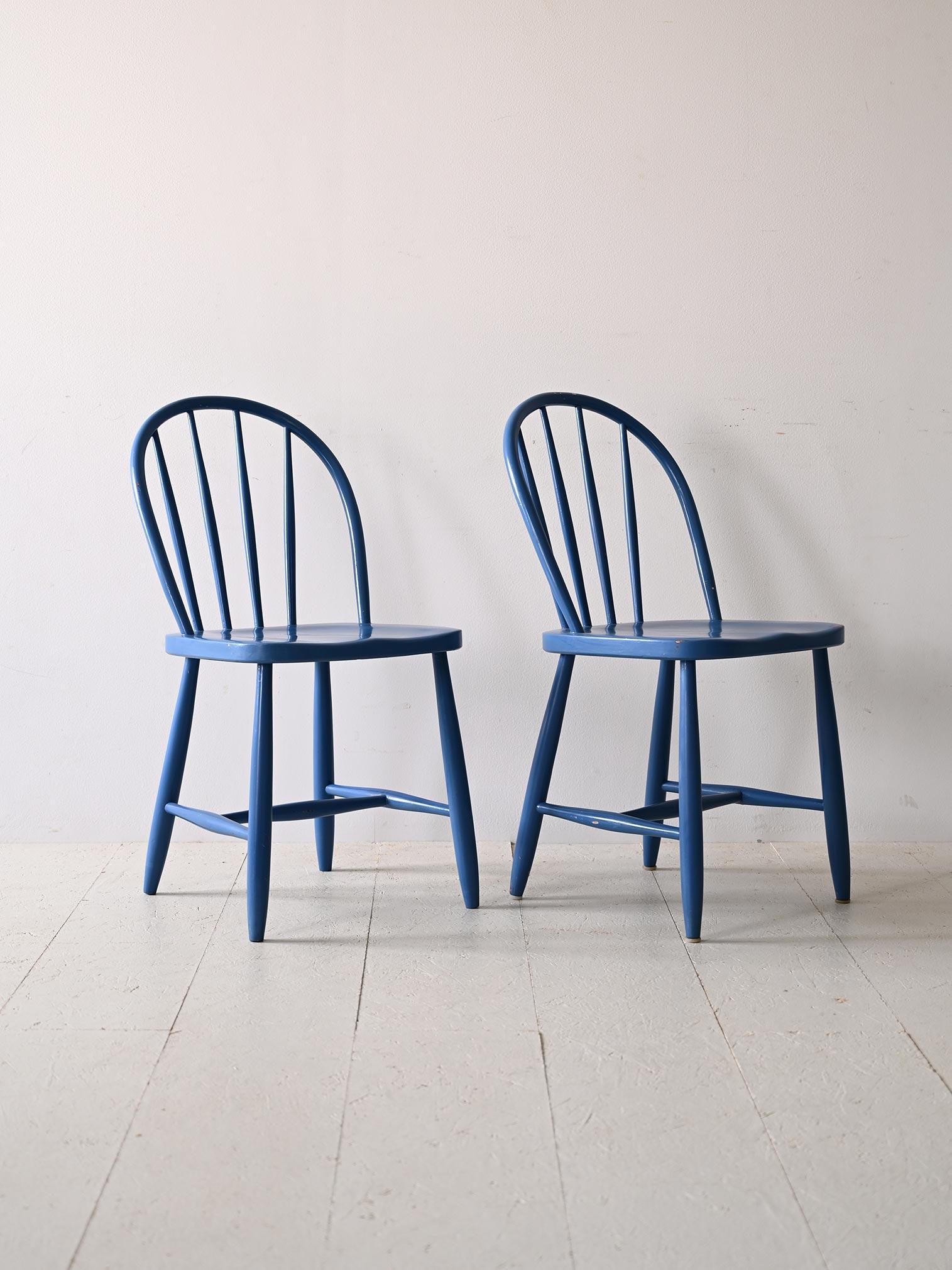 Pair of original Scandinavian 1960s blue wooden chairs.

This pair of wooden chairs features a back and legs with an elegant Nordic design, featuring a rounded shape that extends to both the backrest and tapered legs. Their simple, vintage style