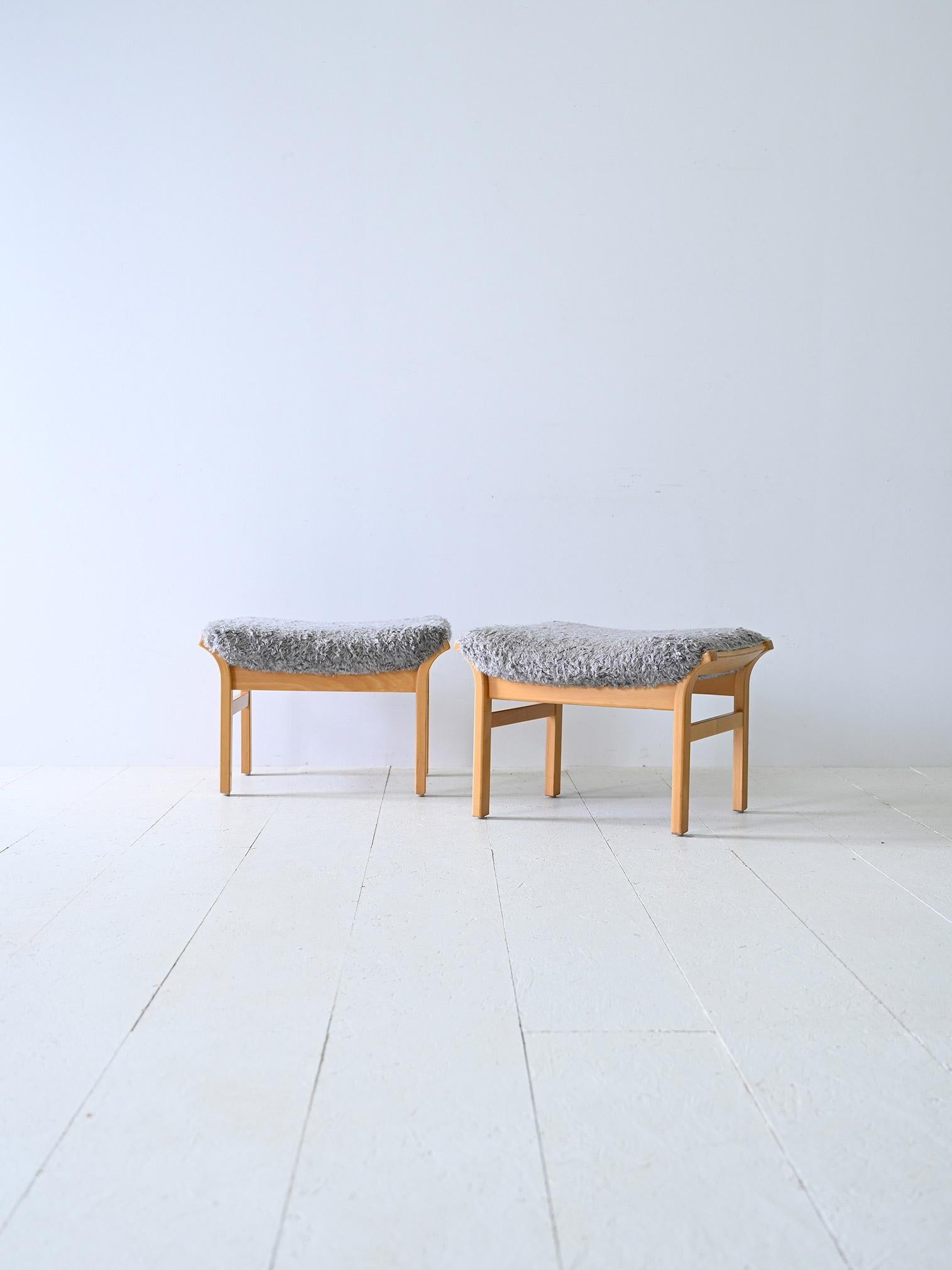 Pair of wooden stools of Scandinavian manufacture.

With slightly squared legs and a light wood frame, these ottomans offer a cozy, Nordic feel. The gray long-haired fabric seat creates a contrast with the wood, giving it a unique style.

The small