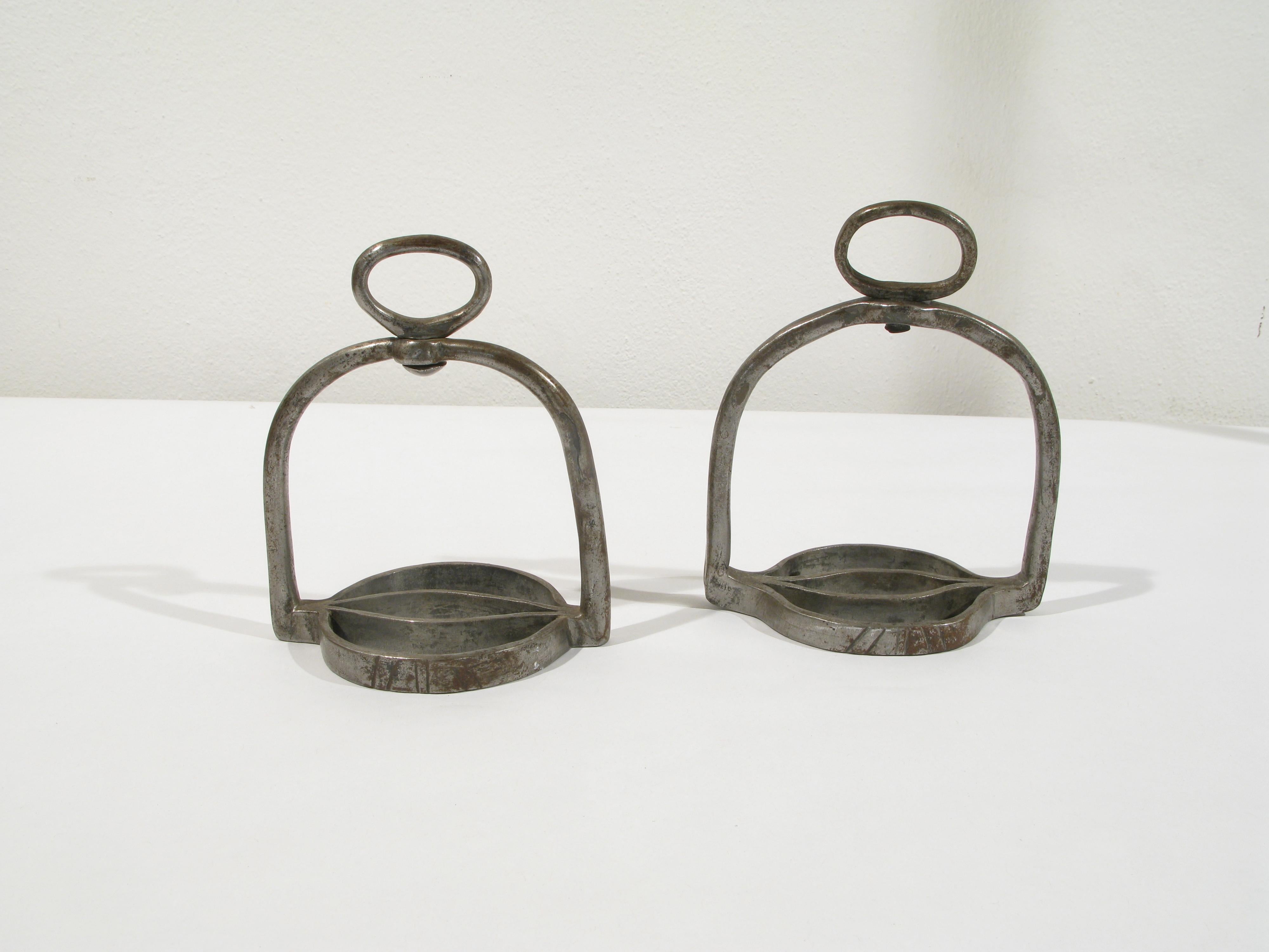 Pair of 19th century riding stirrups  

Made of wrought and engraved iron present the base part,  where it is supported  the foot,  circular in shape. From it start two arched uprights that join at the top;  here a ring allows the brackets to be