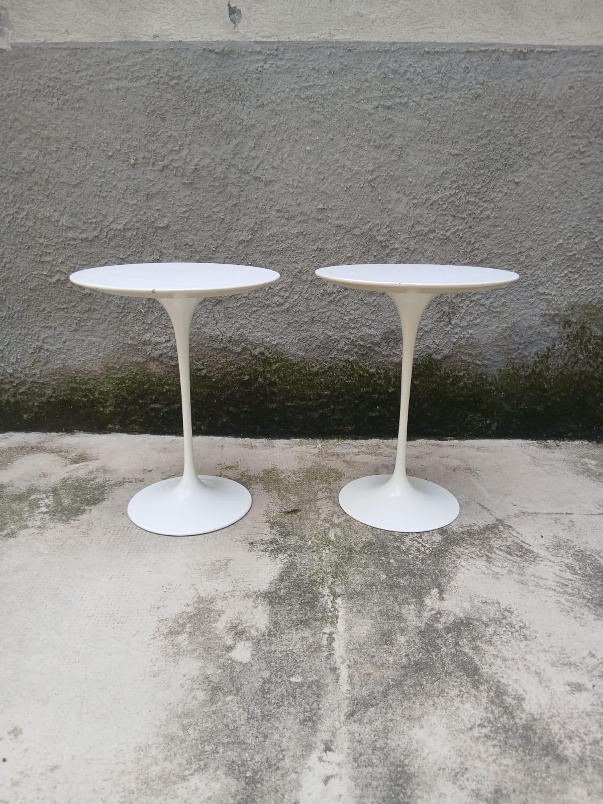 Iconica coppia di tavolini “Tulip” disegnati da Eero Saarinen per Knoll negli anni ’50 e prodotti negli anni ’60. Realizzati con base in alluminio laccato bianco e piano tondo in legno laminato bianco, esprimono la celebre ricerca di Saarinen per un