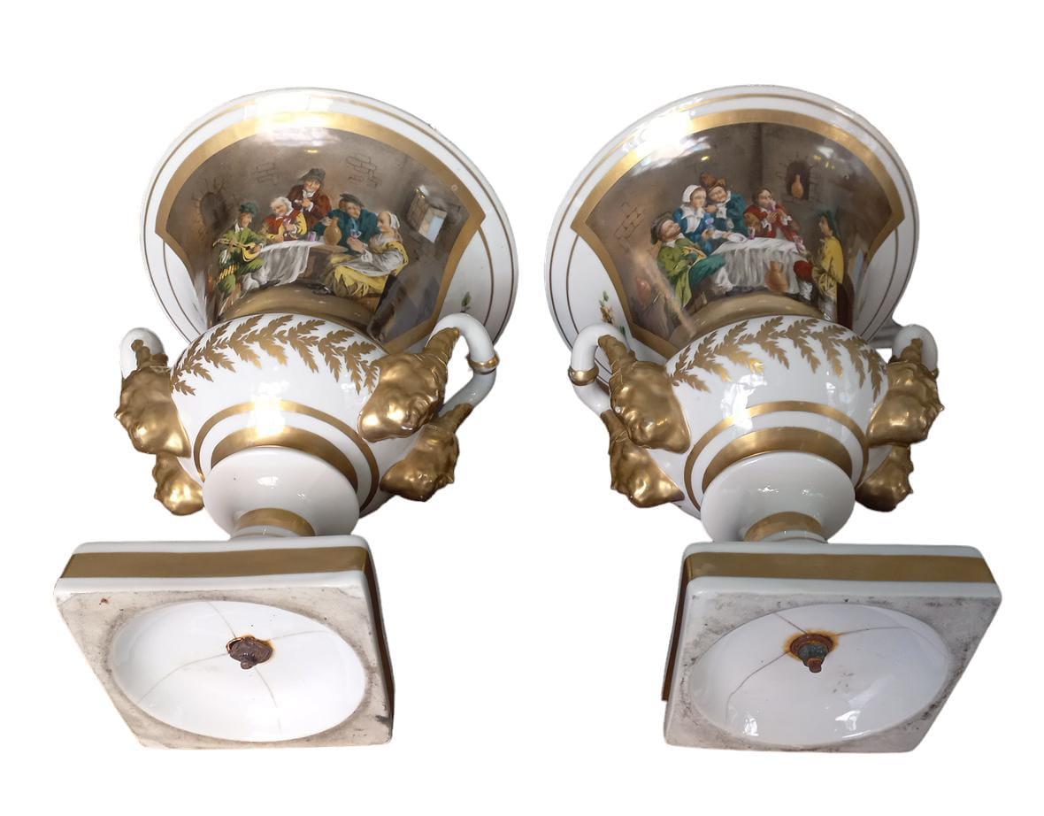 Paire de vases cratères en porcelaine de Paris, bords dorés avec perte marginale de tonalité ; décor de deux scènes de taverne différentes sur un côté et décor de fleurs sur l'autre côté, seconde moitié du 19e siècle, hauteur 38 cm, base 13x13 cm,