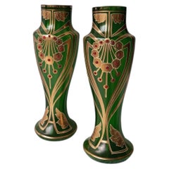 A pair of Art Nouveau vases made of green glass with cabochon stones set into them.