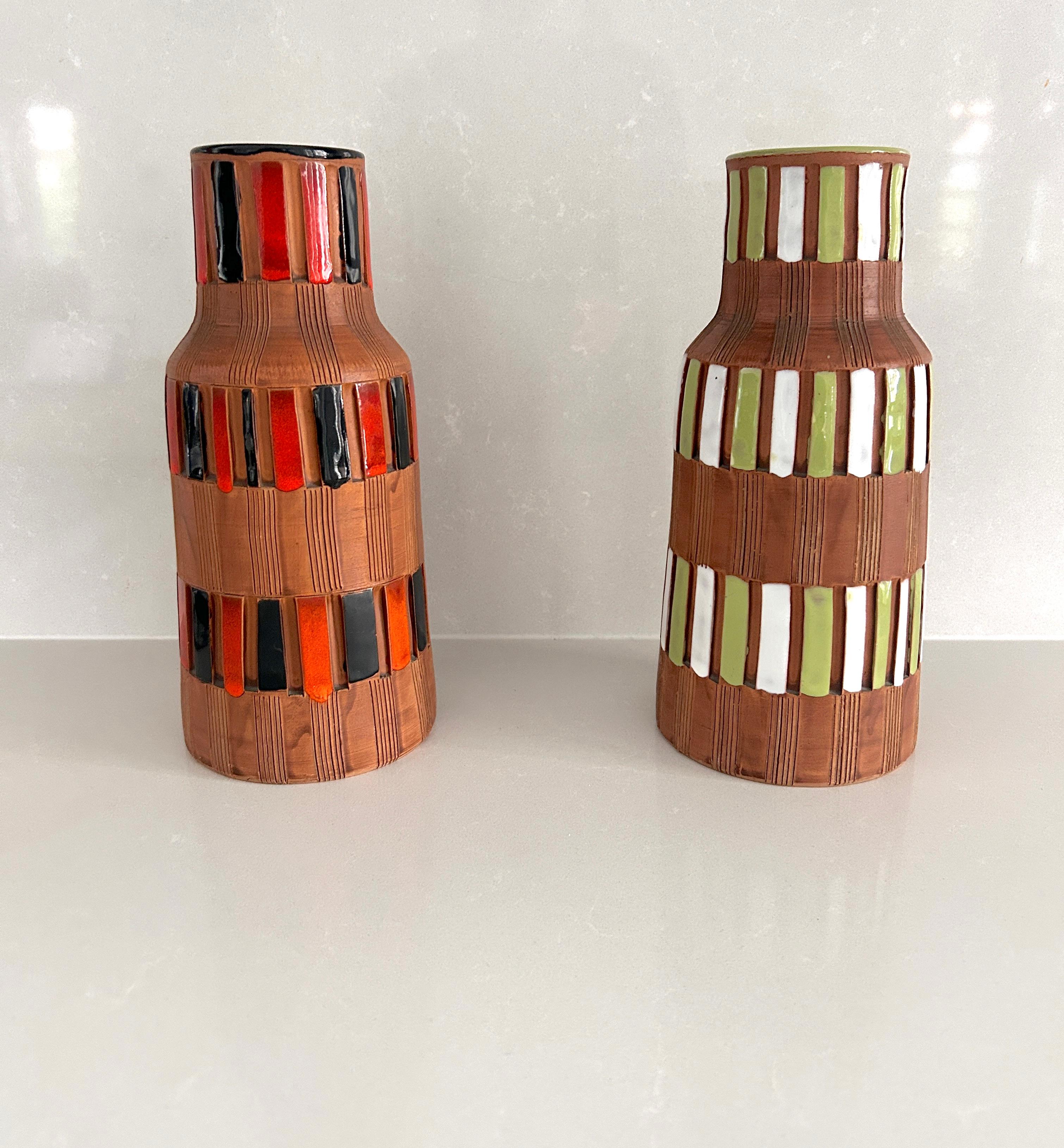 Coppia di vasi portafiori firmati Bitossi. 
Realizzati in ceramica smaltata nei toni del verde - bianco e rosso -nero
Entrambi firmati sotto la base