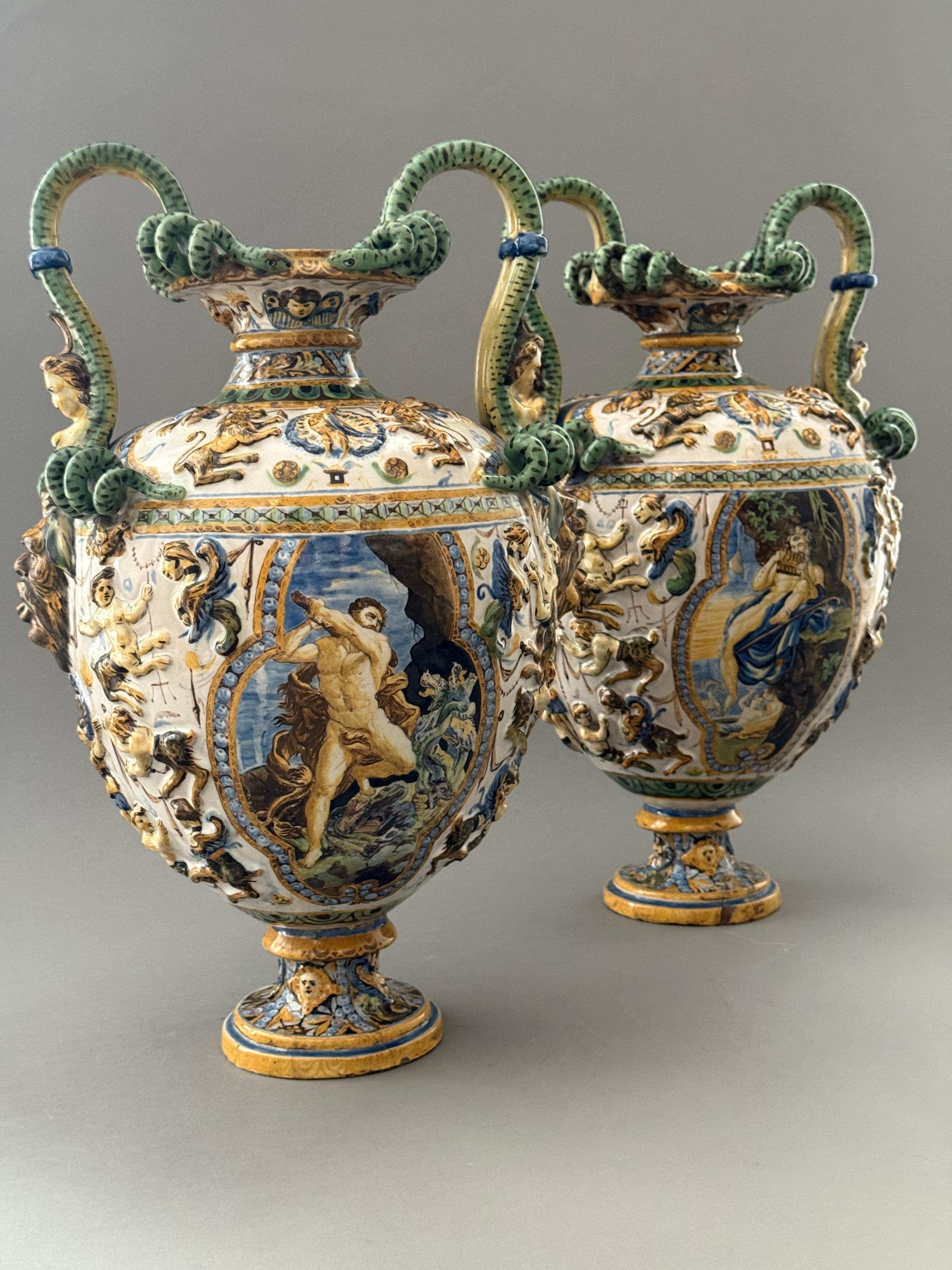 Coppia di vasi in maiolica napoletani del XIX secolo. Die Gefäße mit Rilievo-Dekor zeigen Naturszenen mitologischem und groteskem Charakter, darunter auch Zentren mit einem kämpfenden Dreizack, die Figur des Cadmo, der nach mitologischem Verständnis