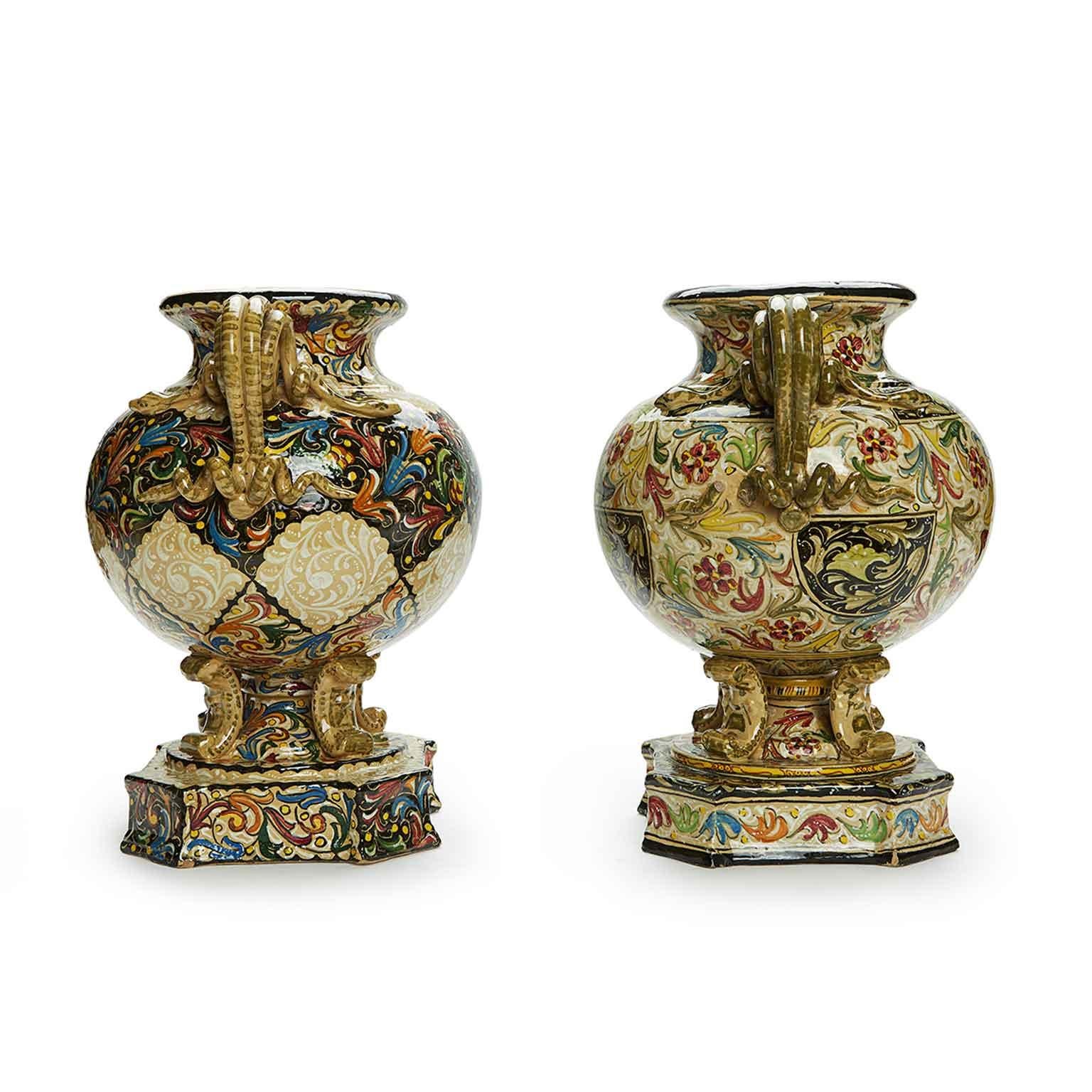Dall'Italia, una splendida coppia di vasi dipinti a mano con manici a forma di serpenti arrorolati, della manifattura Ceramica Molaroni di Pesaro, del 1950 circa, due anfore biansate dalla fattura eclettica, di forma circolare,  poggianti su di un