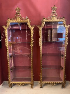 Coppia di vetrinette in legno dorato e intagliato con luce interna, primi '900.